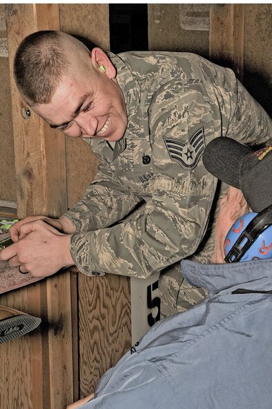 Staff Sgt. Brant Clouss of Kuna, Idaho, a member of the Idaho Air National Guard's 124th Fighter Wing Marksmanship team, reloads U.S. Navy veteran Richard Nelson's .22 caliber rifle Feb. 29 at the Boise Rifle and Pistol Club. Clouss, a security policeman from the 124th Security Forces Squadron, was one of several young marksmen who took time away from his family to support the event. "It's fun to do this and give back to them for their service," Clouss said.