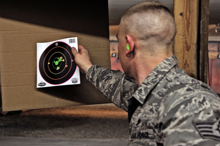 Staff Sgt. Brant Clouss of Kuna, Idaho, a member of the Idaho Air National Guard's 124th Fighter Wing Marksmanship team, removes a target at the Boise Rifle and Pistol Club Feb. 29. Clouss, who works full-time as a security policeman for the 124th Security Forces Squadron, and other marksmen took out from practice to honor local veterans with an evening of fun and friendly competition.