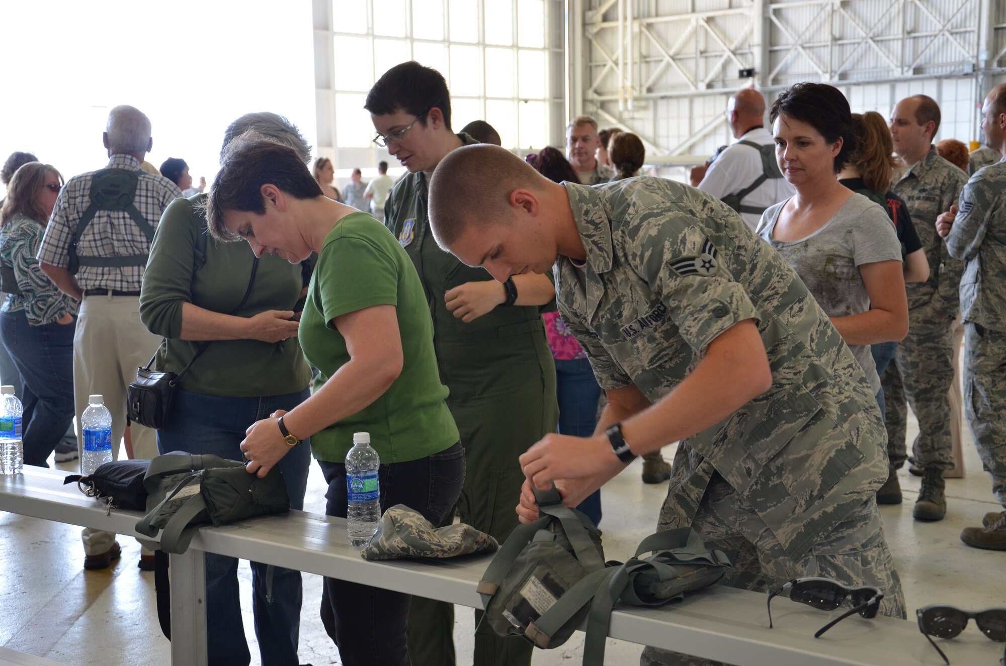 Reserve Airmen from the 920th Rescue Wing prepare flight equipment for spouses and employers of Reservists about to board an HH-60 Pave Hawk helicopter over to fly Florida’s Atlantic Coast. The flight was part of Family Day at Patrick Air Force Base, Fla. (U.S. Air Force photo/Staff Sgt. Anna-Marie Wyant)
