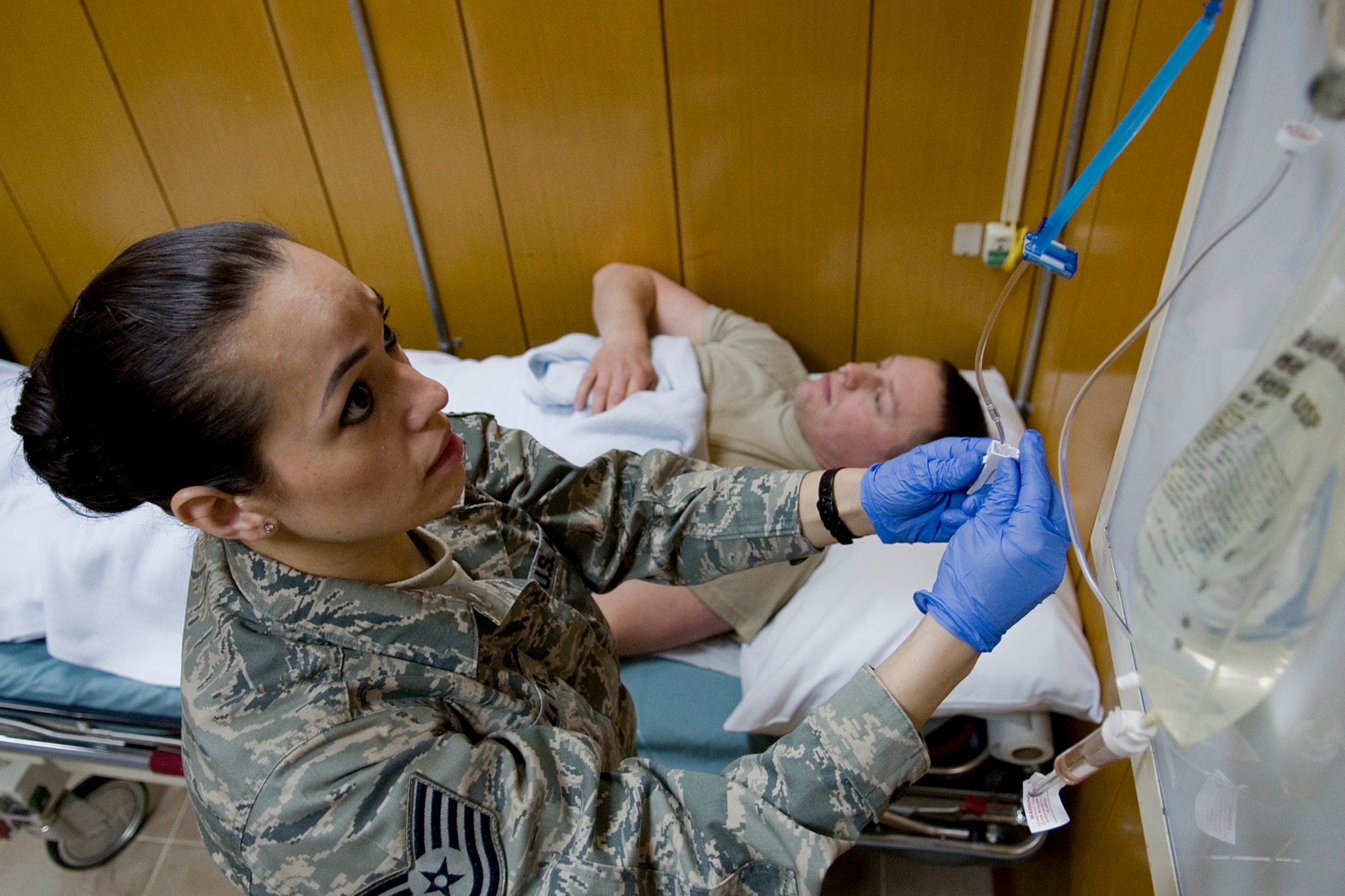GRISSOM AIR RESERVE BASE, Ind. -- Tech Sgt. Rosalba DeLapaz, 74th Air Refueling Squadron medical element technician, fastens an intravenous fluid line for Master Sgt. Mike Morris, 434th Communications Squadron client systems technician, during a recent deployment to Incirlik Air Base, Turkey March 1. The deployers' teamwork and can-do attitude delivered world-class care so that troops wouldn't miss a beat. (U.S. Air Force photo/Senior Airman Jami K. Lancette) 