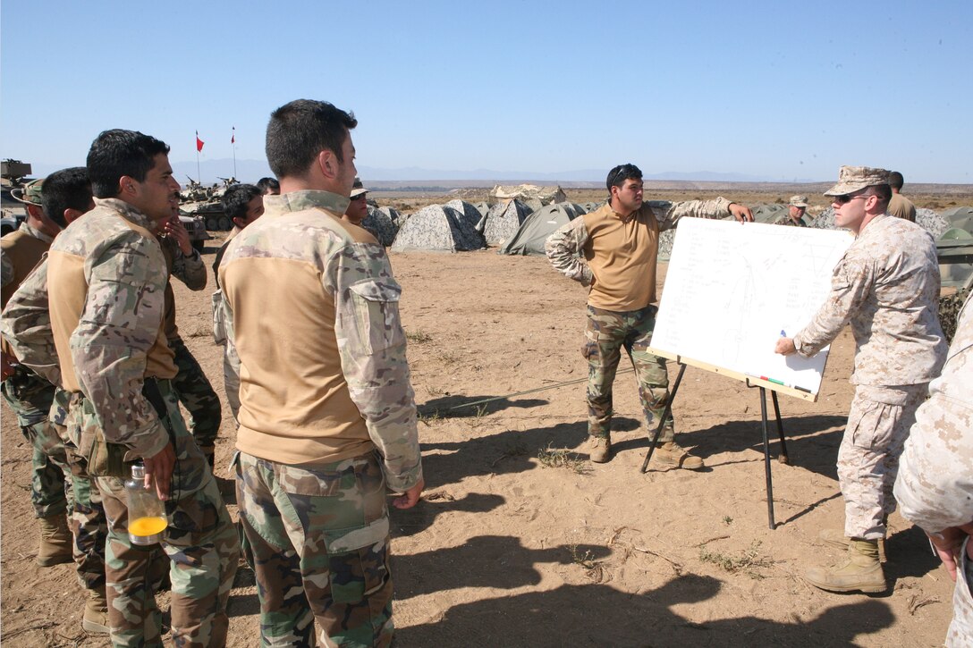 Marine Capt. Devin Myler, an F-18 pilot, who currently serves as the air officer at MCSCG, explains how U.S. Marines coordinate and plan for close air support with Marines from the Chilean Marine Corps’ Second Marine Detachment “Miller” at Puerto Aldea, Chile. Myler, who is a native of Washington, D.C. and a U.S. Naval Academy graduate, was one of three Marines who participated in a air and surface fires delivery Subjec Matter Expert Exchange with the Chilean Marines from March 13 - 18.