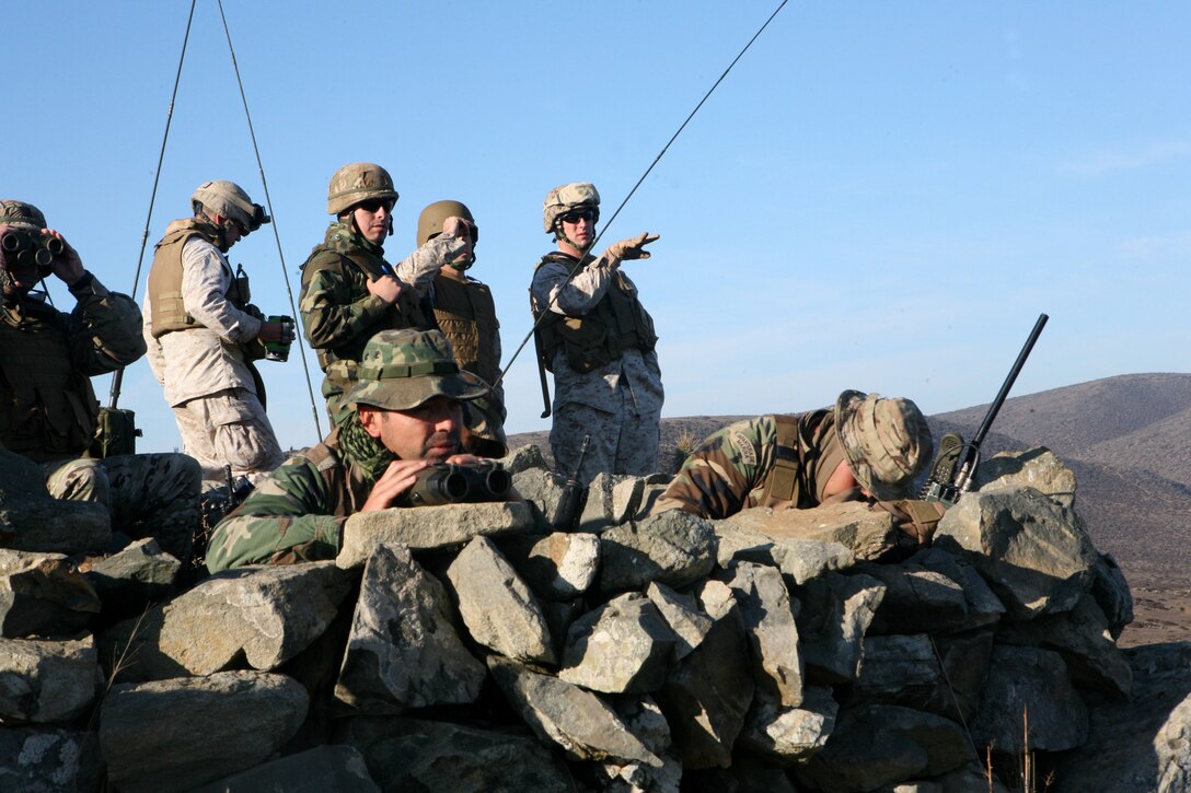 Gunnery Sgt. Shaun Leek (rear right), Capt. Devin Myler and Capt. Blaine Barby from Marine Corps Security Cooperation Group participated in a subject matter expert exchange with Marines from Second Marine Detachment Miller of the Republic of Chile's Marine Corps (Cuerpo de Infanteria Marina de la Armada de Chile), at Puerto Aldea, Chile, May 14-18. Subject matter expert exchanges such as this one (fire support coordination ) are part of a long-term regional engagement plan by U.S Southern Command and U.S. Marine Corps Forces, South, towards increasing service partnerships and improving each country's capabilities and interoperability. ::r::::n::