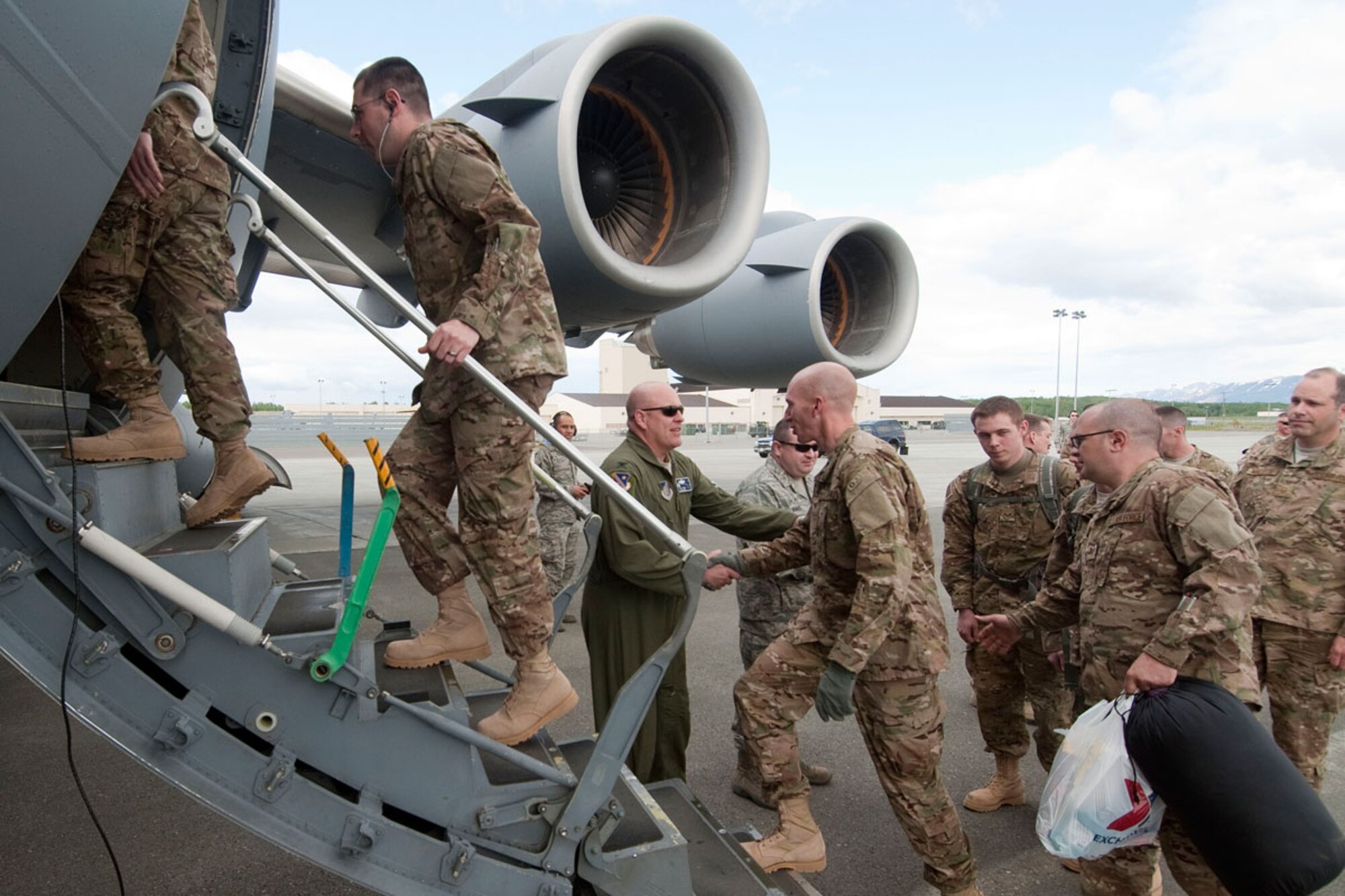 Deploying members of the Alaska Air National Guard’s 176th Wing shake hands with their commander, Col. Scott Wenke, as they board a C-17 Globemaster III cargo aircraft for Afghanistan Monday. (U.S. Air Force photo/Capt. John Callahan)