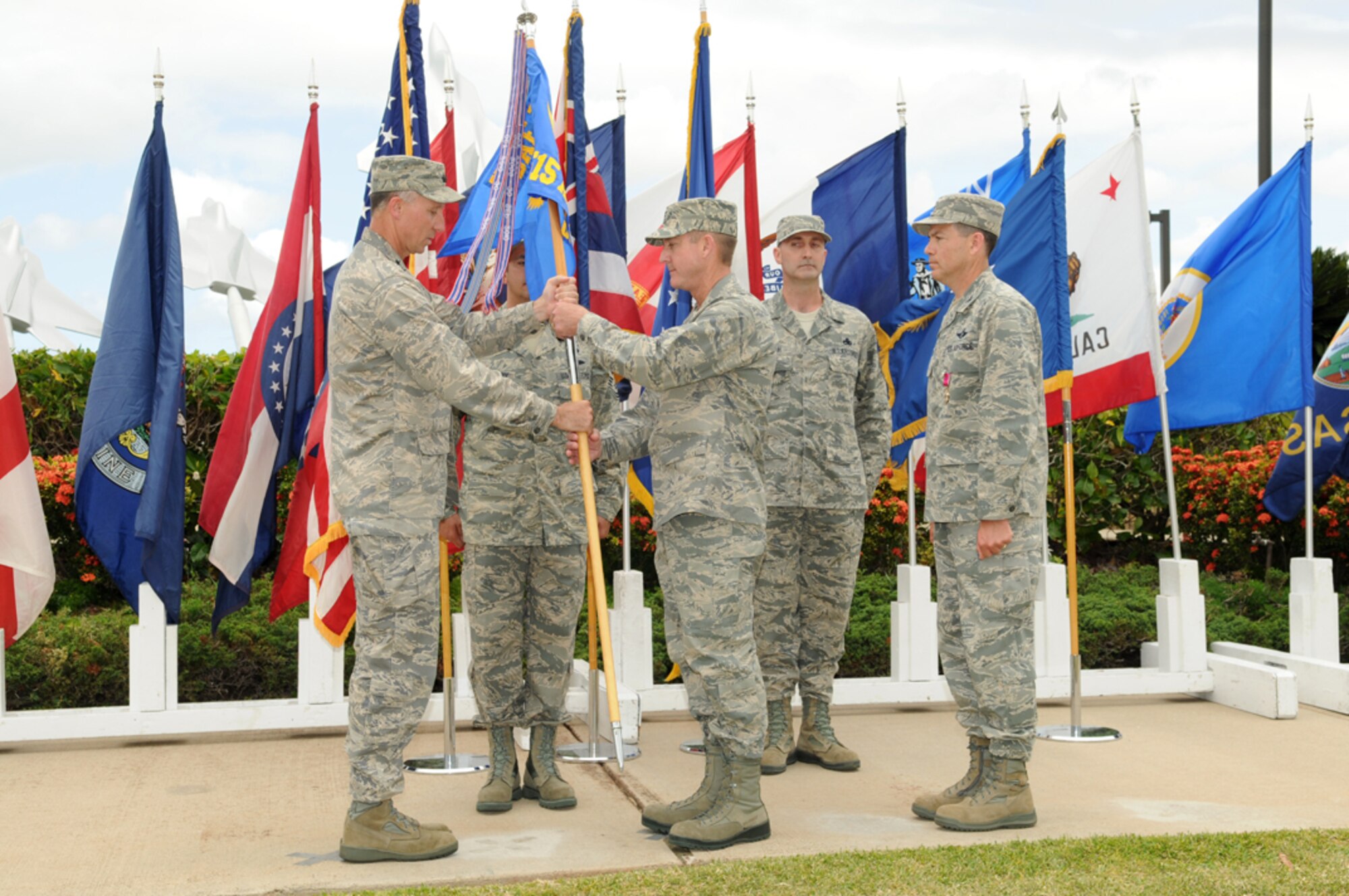 Brig. Gen. William Bender (left), commander of the U.S. Air Force Expeditionary Center at Joint Base McGuire-Dix-Lakehurst, N.J., passes the 515th Air Mobility Operations Wing (AMOW) guidon to Col. Douglas K. Lamberth during a change of command ceremony May 30 for the 515th AMOW at the Missing Man Formation Memorial at Joint Base Pearl Harbor-Hickam. Lamberth assumed command of the 515th AMOW from Col. Stephen Oliver. (U.S. Navy photo by David D. Underwood Jr.)