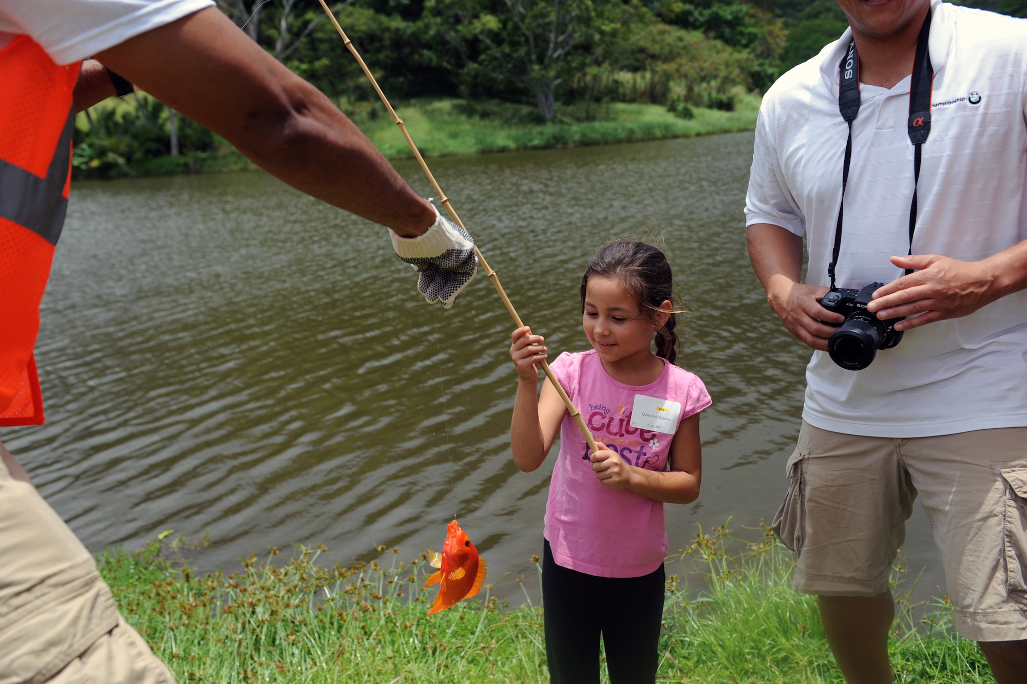 A Keiki Fishing Tournament participant shows off her catch to a volunteer fishing marshal at the 2012 Keiki Fishing Tournament May 30 at Ho'omaluhia Botanical Gardens in Kaneohe, Hawaii. The fishing tournament was sponsored by the Friends of Hickam, a group of community leaders who facilitate between the 15th Wing and the Hawaii community seeking to support, promote, and foster stronger community relations with those associated with the 15th Wing. (U.S. Air Force photo by Staff Sgt. Nathan Allen)