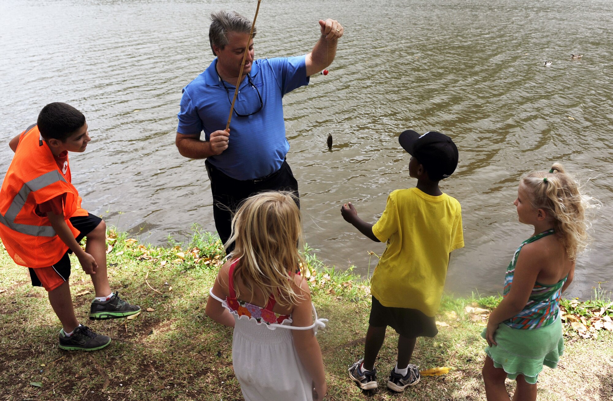 Bruce Shewalter, Friends of Hickam President, shows off the first catch of the day to participants in the 2012 Keiki Fishing Tournament May 30 at Ho'omaluhia Botanical Gardens in Kaneohe, Hawaii. The fishing tournament was sponsored by the Friends of Hickam, a group of community leaders who facilitate between the 15th Wing at Joint Base Pearl Harbor-Hickam, Hawaii, and the Hawaii community seeking to support, promote, and foster stronger community relations with those associated with the 15th Wing. (U.S. Air Force photo by Staff Sgt. Nathan Allen)