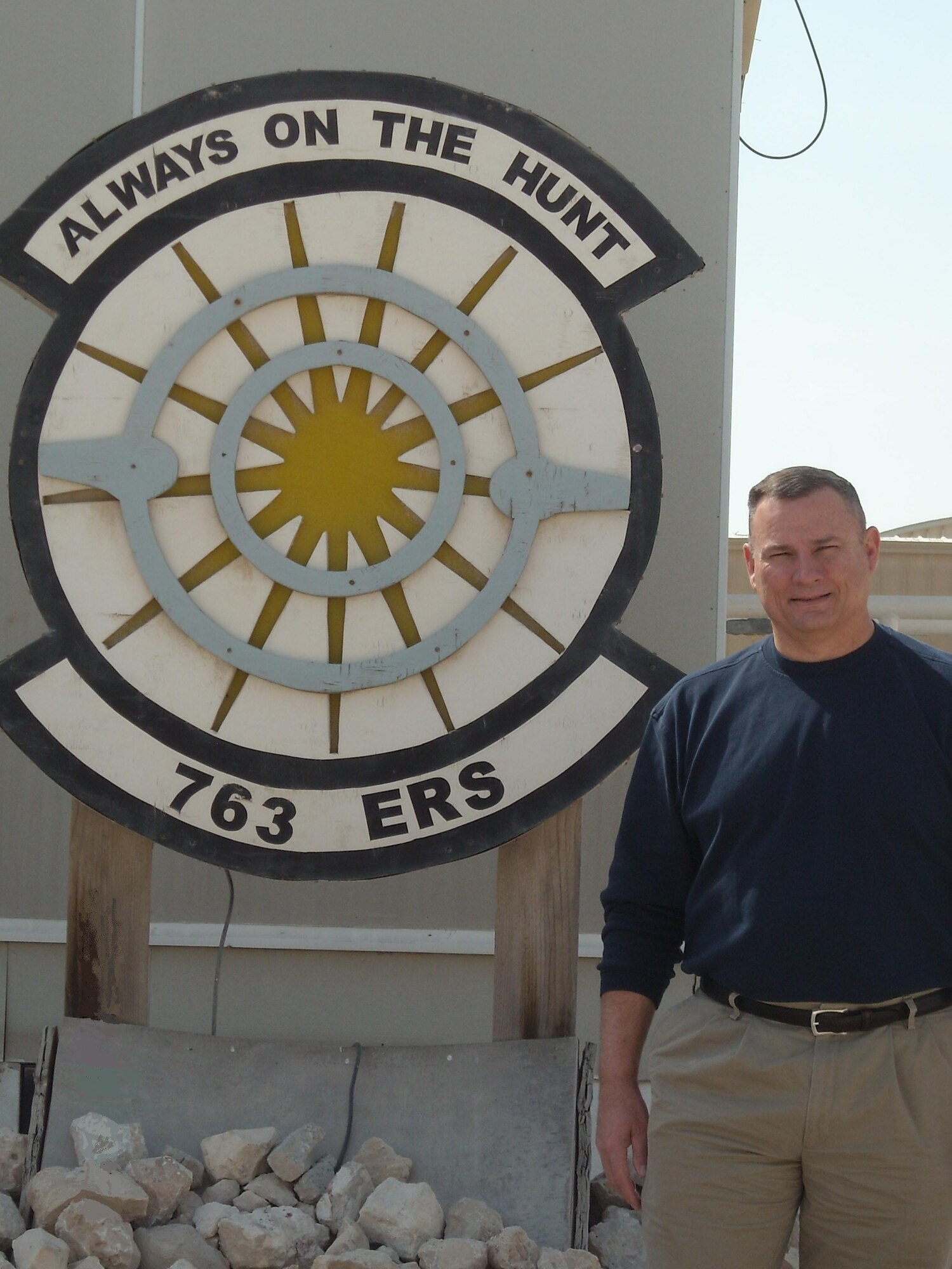 Dave Pearson, 497th Intelligence, Surveillance and Reconnaissance Group, Langley Air Force Base, Va., stands next to the shield for the 763rd Expeditionary Reconnaissance Squadron, Southwest Asia.  Pearson, the first civilian to deploy from the 480th ISR Wing, recently returned from a 90-day assignment and highly recommends deploying to other civilians. (Courtesy photo)