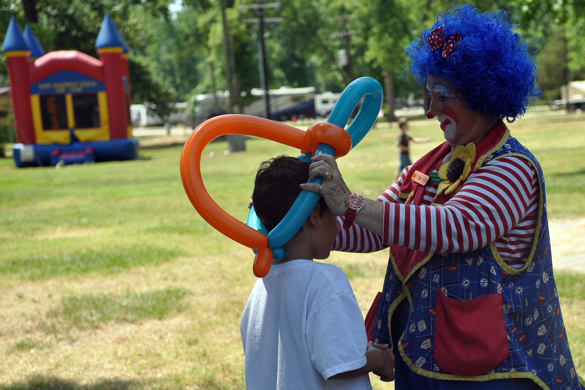 CiCi the Clown adorns a child with a balloon hat during the 307th Bomb Wing/917th Fighter Group Family Day at Cullen Park on Barksdale Air Force Base, La., June 2, 2012. The annual event is an opportunity for the Reservists and their families to get together for some fun and camaraderie. (U.S. Air Force photo/Betty Stephens)