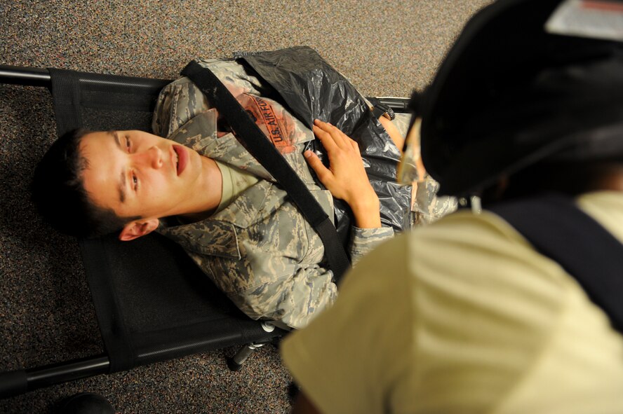 Emergency medical personnel perform self-aid and buddy care to a victim during an active shooter exercise at Moody Air Force Base, Ga., June 1, 2012. After the area was secured, the medical team moved in to help and evacuate the wounded. (U.S. Air Force photo by Airman 1st Class Douglas Ellis/Released)     

