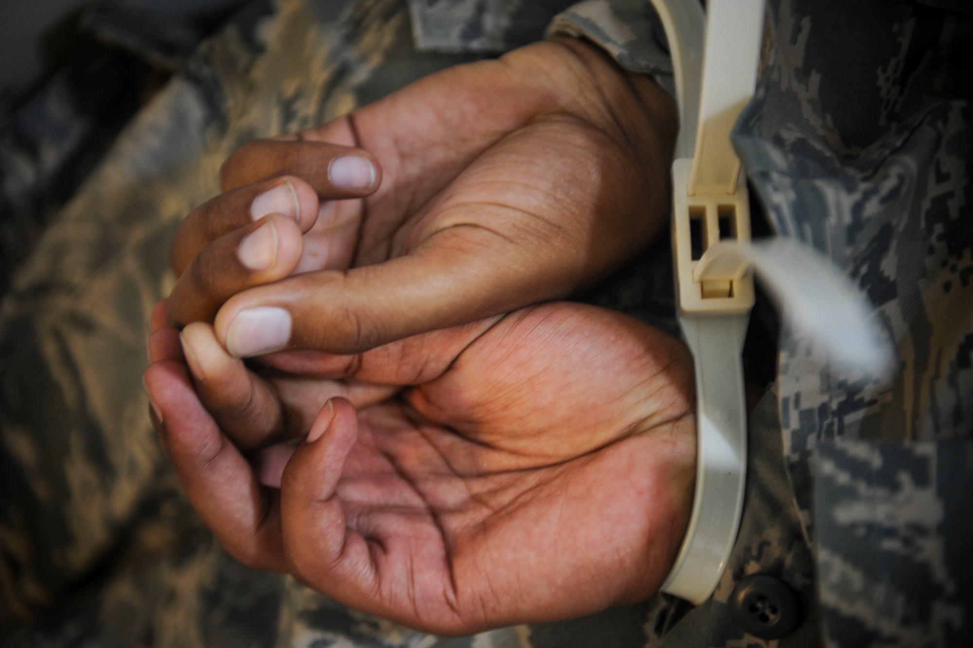 U.S. Air Force Airman 1st Class Michael Kinsey, 23d Medical Operations Squadron plans and scheduling apprentice, lies on the floor after being handcuffed by security forces during an active shooter exercise at Moody Air Force Base, Ga., June 1, 2012. The security forces Airmen successfully cleared the building, evacuated the injured hostages and detained the gunman. (U.S. Air Force photo by Airman 1st Class Douglas Ellis/Released)
