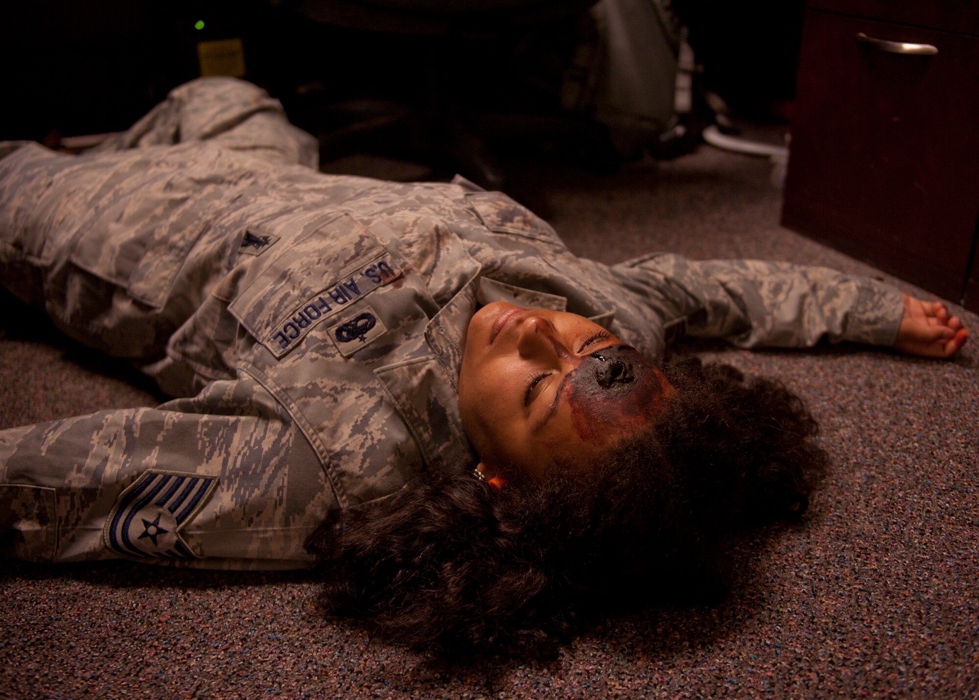 U.S. Air Force Airman 1st Class Automne Hasenberg, 23d Force Support Squadron, plays the role of a gunshot victim during an active shooter exercise June 1, 2012, at Moody Air Force Base, Ga. Hasenberg, along with other volunteers, received mock injuries to play victims and add a sense of realism during the exercise. (U.S. Air Force photo by Senior Airman Eileen Meier/Released)