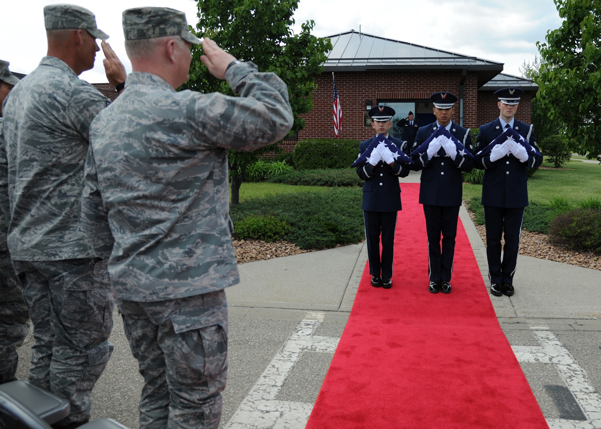 Command Chief Master Sergeant David Carlson, 319th Air Base Wing, and Col. Scott Rizer, 319th ABW vice commander, salute the flags given to Chief Master Sgt. Harry Walker’s family during a rededication ceremony at the Walker Warrior Professional Development Center, on May 30, 2012, on Grand Forks Air Force Base, N.D. (U.S. Air Force photo/Airman 1st Class Ashley N. Taylor)