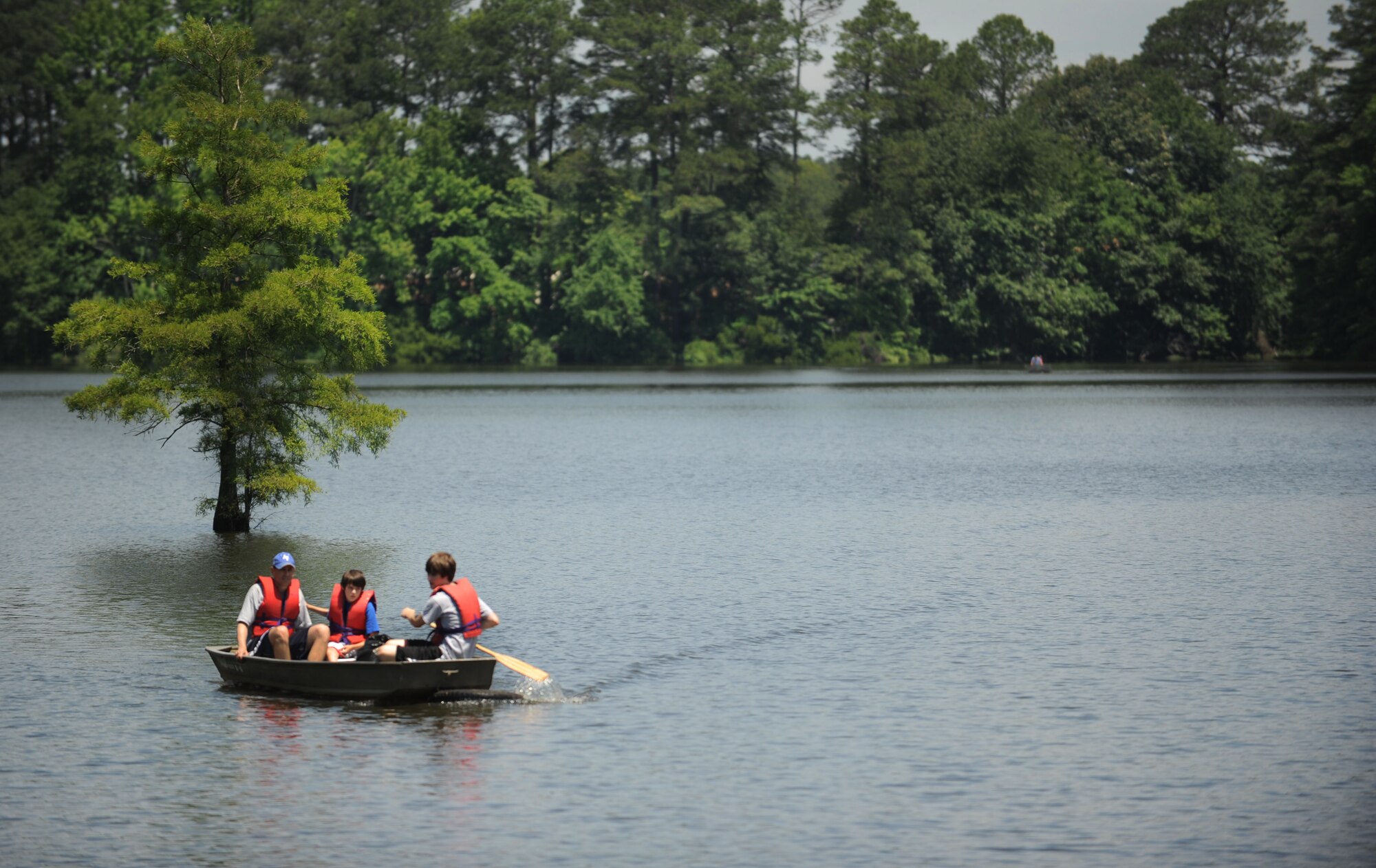 Col. Korvin Auch, left, 633rd Air Base Wing commander, and his sons pilot a boat full of trash toward the dock at Langley Air Force Base, Va., June 2, 2012. Auch and his sons joined Airmen from base in cleaning trash from the Chesapeake Bay during the 2012 Clean the Bay Day event. (U.S. Air Force photo by Senior Airman Jarad A. Denton/Released)