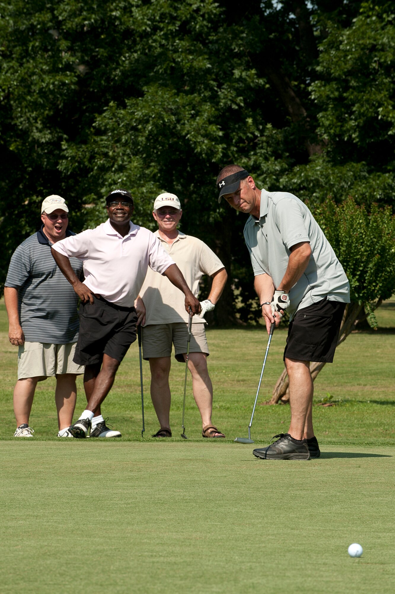 U.S. Air Force Lt. Col. Gary Avollone, Maj. Dennis Britten, Lt. Col. Al Smith and Maj. Flavius Alligood react as the golf ball stops just inches from the hole while playing in the Commander’s Cup Golf Tournament, Barksdale Air Force Base, La., June 2, 2012. They are all members of the 307th Medical Squadron and the tournament was hosted by the 307th Bomb Wing and 917th Fighter Group. (U.S. Air Force photo by Master Sgt. Greg Steele/Released)