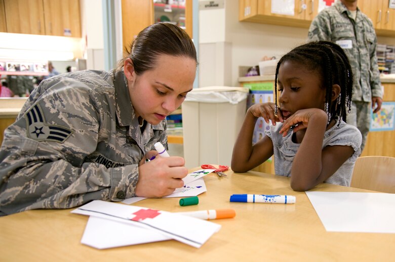 Senior Airman Laura Kinglocke, a medical technician at 1st Special Operations Medical Operations Squadron, helps Samaiya Garden, a pre-kindergarten student, design a nurse’s cap at Child Development Center East at Hurlburt Field, Fla., May 10, 2012. Medical technicians and nurses from Hurlburt Field’s clinic celebrated Nurse and Technician Week by teaching children about the profession. (U.S. Air Force photo / Airman 1st Class Michelle Vickers) (RELEASED) 
