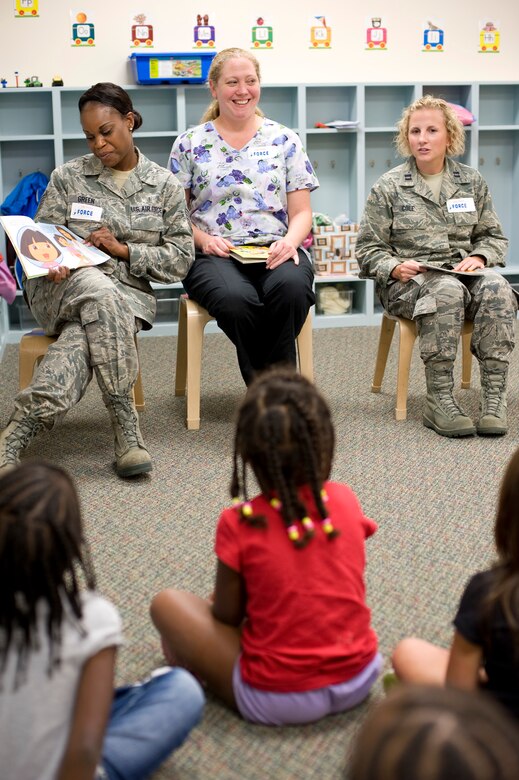 Tech Sgt. Kezia Green, a pediatric medical technician at 1st Special Operations Medical Operations Squadron, left, shares a picture book with a class as Amy Sanders, a registered nurse at 1 SOMDOS, center, and Capt. Jessica Cole, family health clinic nurse manager at 1 SOMDOS, right, look on at the Child Development Center East at Hurlburt Field, Fla., May 10, 2012. The nurses and medical technicians participated in a children’s outreach to familiarize children with nursing.  (U.S. Air Force photo / Airman 1st Class Michelle Vickers) (RELEASED) 
