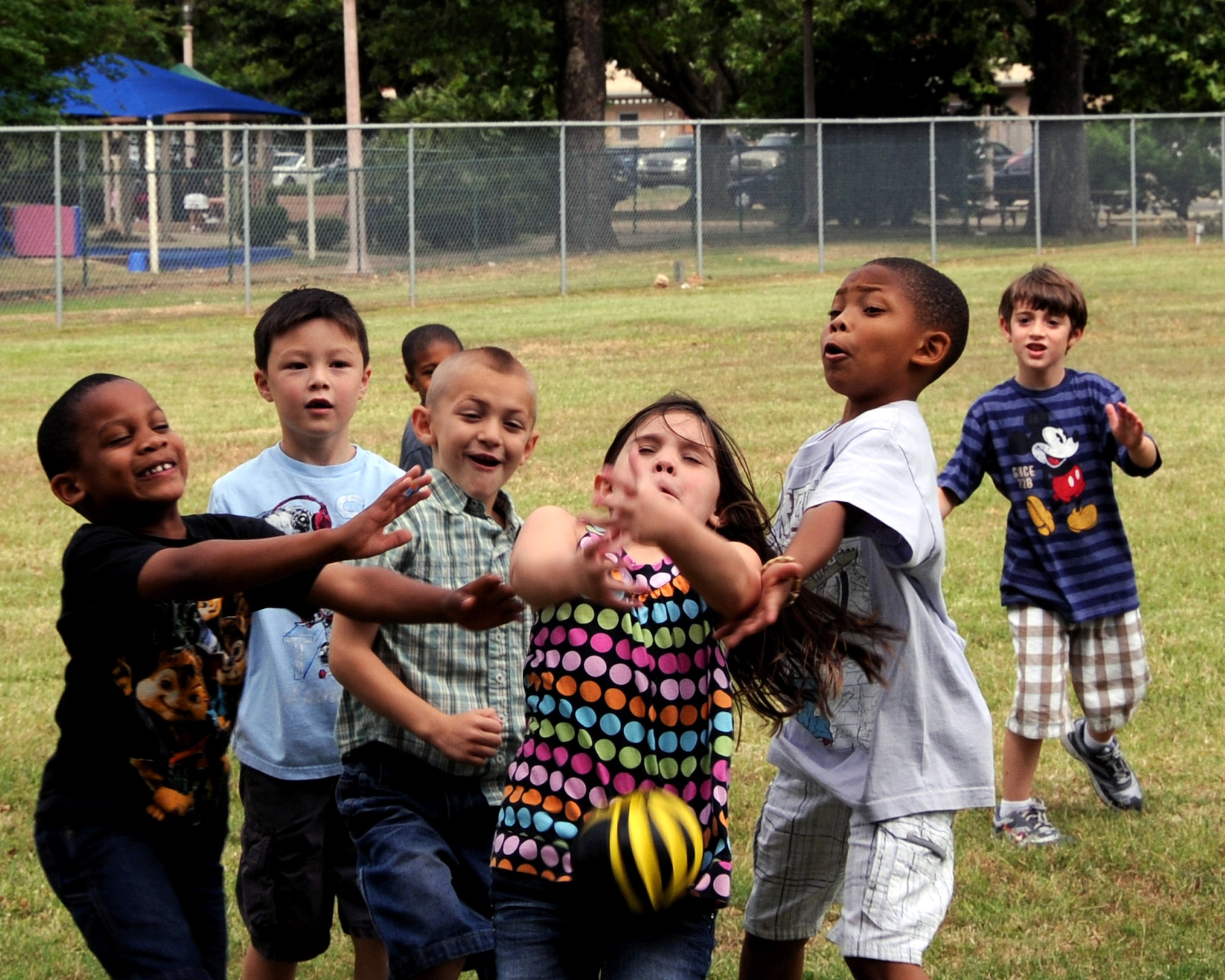 Children attending the Barksdale Youth Center summer camp attempt to catch a ball during recess on Barksdale Air Force Base, La., May 31. The camp offers a variety of activities such as science projects, arts and crafts, field trips, life skills and a reading program. (U.S. Air Force photo/Senior Airman La'Shanette V. Garrett)(RELEASED)