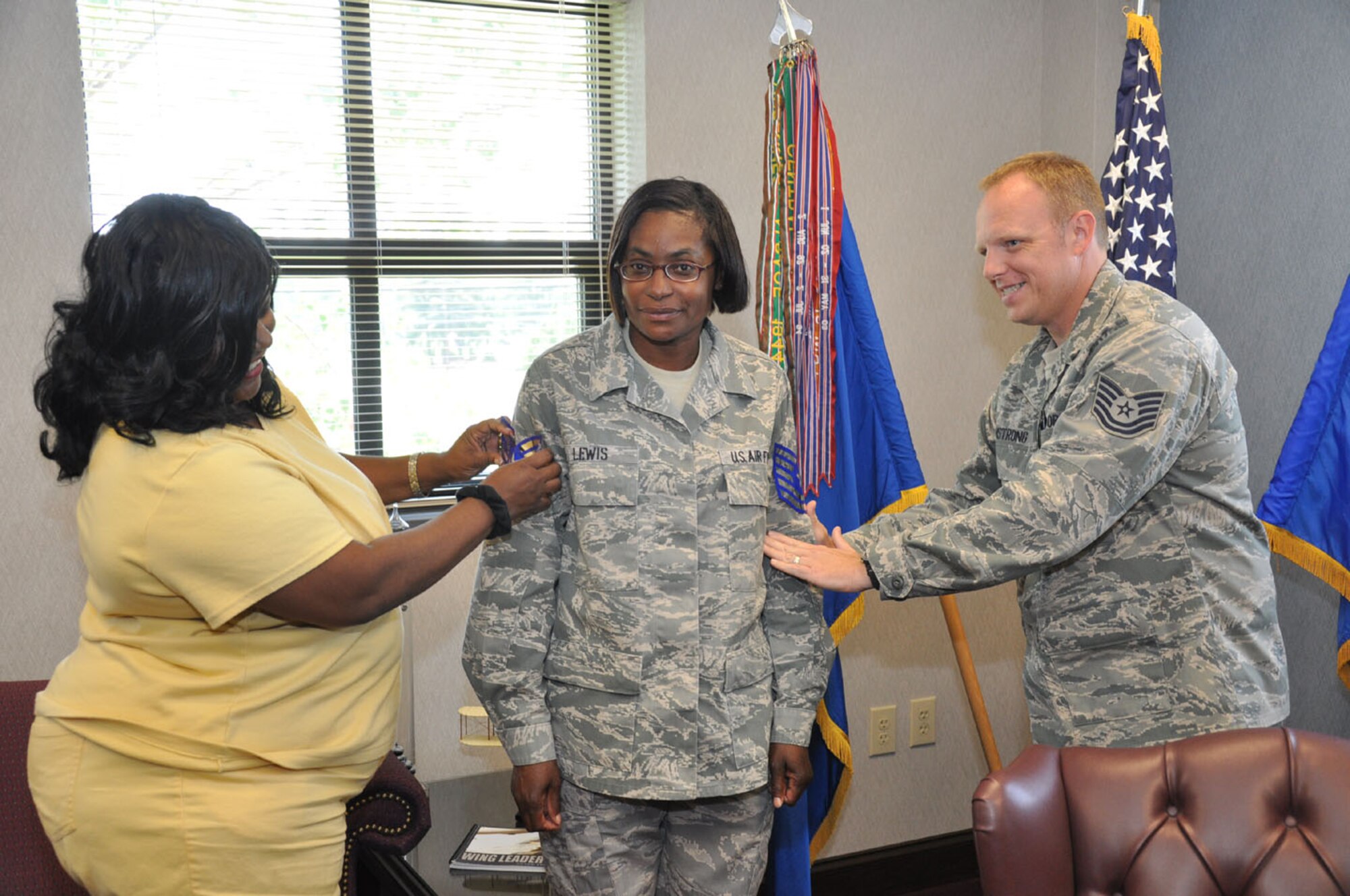 Reservist Glenda Lewis, center, is promoted to the rank of technical sergeant during the June drill weekend. Lewis serves on wing staff. (USAF photo by Staff Sgt. Mark Thompson, 916ARW/PA, released)