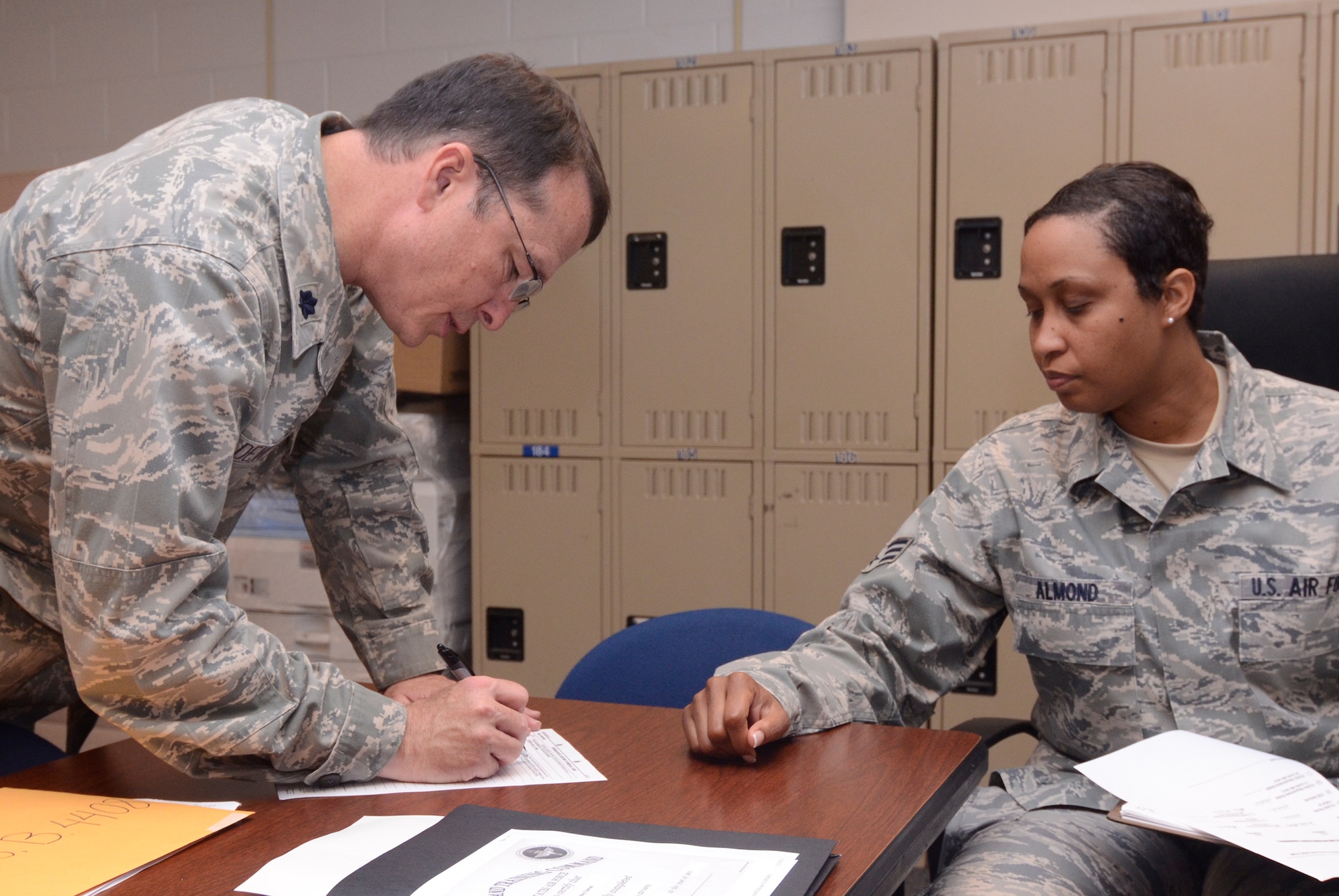 Lt. Col. Kim Devoto, a Medical Service Corp. officer from the Office of the Surgeon General, Pentagon, completes the last portion of his out processing, assisted by Senior Airman Karah M. Almond, a team member from the Readiness Management Group’s Centralized Deployment Processing Center, Dobbins Air Reserve Base, Ga., May 25. (U.S. Air Force photo/Don Peek)