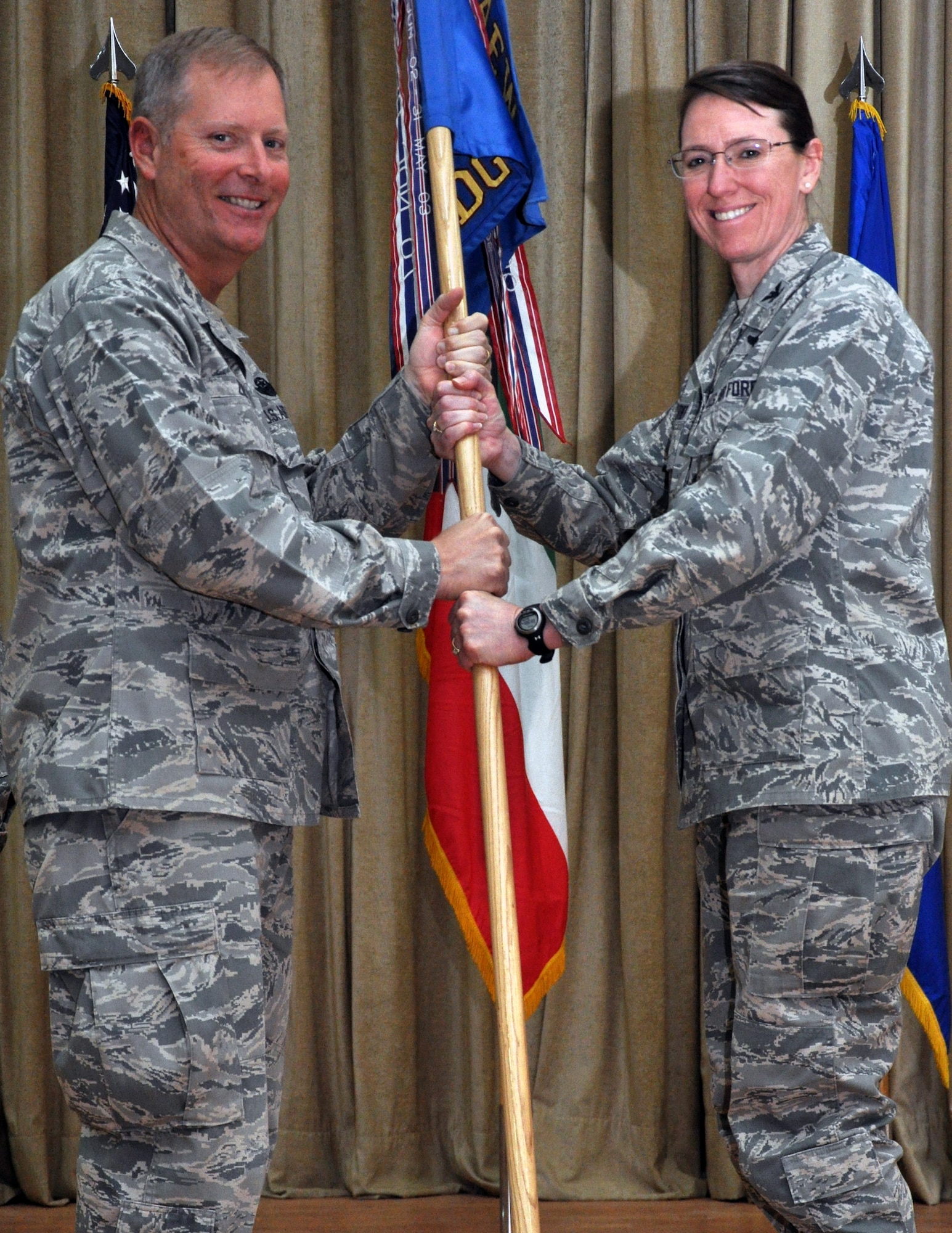 Col. Michael Zick, 386th Air Expeditionary Wing commander, gives the 386th Expeditionary Medical Group guideon to Col. Virginia Garner, the new 386th EMDG commander, during a change of command ceremony June 3, 2012.  Garner will be fulfilling a 365-day permanent change of station here, a first for 386th EMDG commanders. (U.S. Air Force photo/Tech. Sgt. Stacy Fowler)