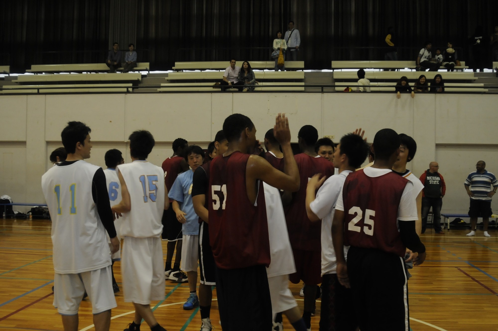 Members of the Japanese and Misawa Air Base basketball teams celebrate at the end of their game at the 24th Annual American Day at Misawa City, Japan, June 3, 2012.  The two teams competed in an exhibition game that left the Americans victorious. American Day is an event hosted by the Misawa International Club and the 35th Fighter Wing to celebrate the strong bilateral relations between Misawa Air Base and the Japanese community. (U.S. Air Force photo by Airman 1st Class Zachary Kee/Released)
