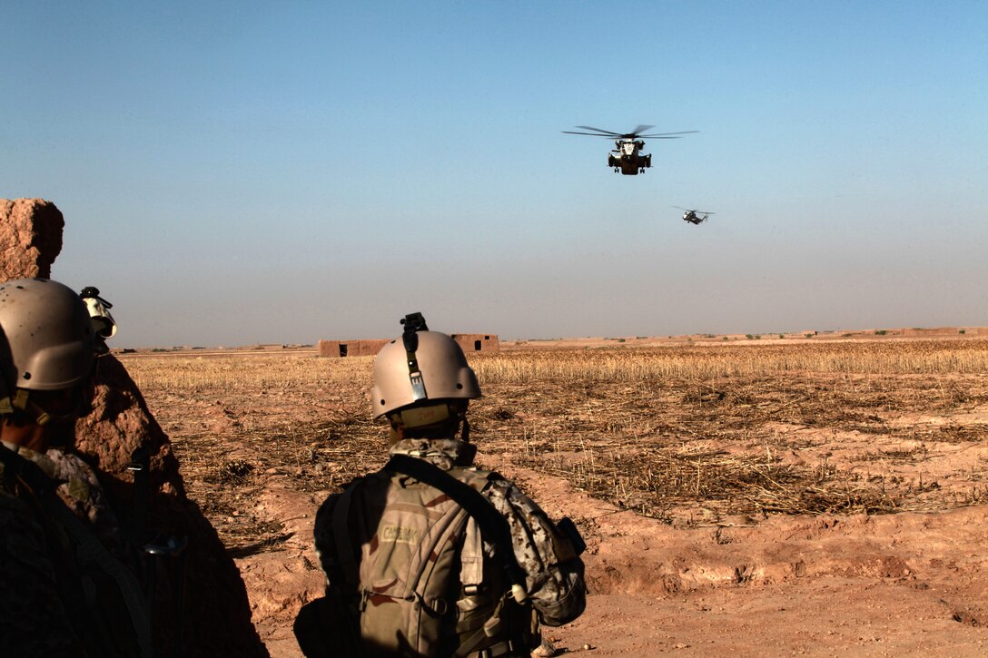 Marines with 2nd Battalion, 9th Marine Regiment, and members of the Afghan National Interdiction Unit, wait to be extracted by two CH-53D Sea Stallions, from Marine Heavy Helicopter Squadron 362, in Helmand province, Afghanistan, June 4. Helicopters from the squadron transported the ground units to and from three different areas of the province to conduct counternarcotics operations.