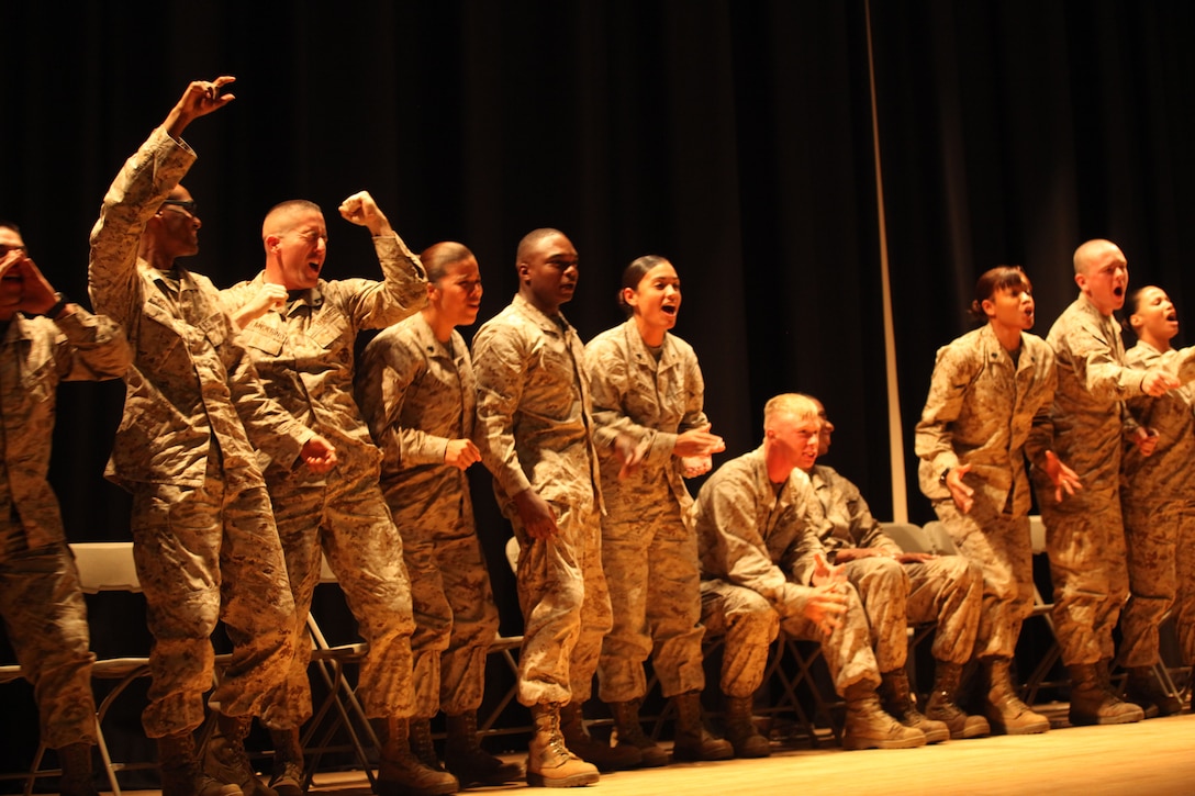 Marines who were hypnotized by Bryan McDaniel cheer during an imaginary horse race at the Base Theater aboard Marine Corps Base Camp Lejeune, May 22. McDaniel mixes laughs with a strong antidrunk driving message during his stage hypnosis shows.