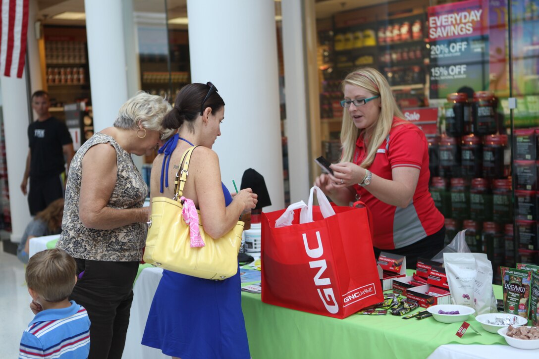A Marine Corps Exchange vendor talks about some give aways during the MCX's Health and Fitness Week aboard Marine Corps Base Camp Lejeune, May 25. Vendors were able to highlight their products during the event. 