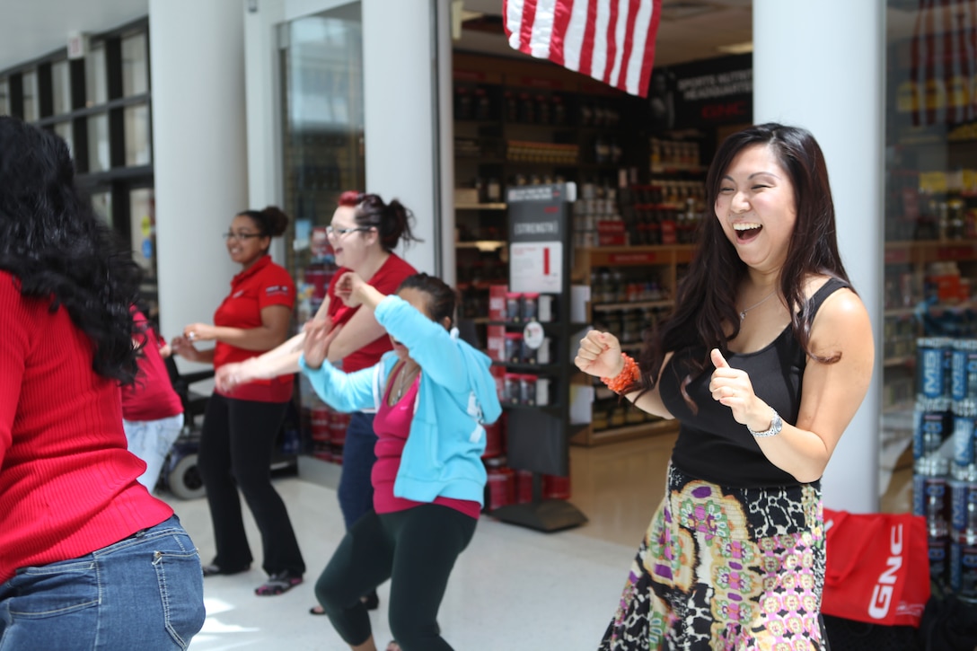 A women laughs while participating in a Zumba class held by Semper Fit at the Marine Corps Exchange aboard Marine Corps Base Camp Lejeune, May 25. Semper Fit was there as a part of Health and Fitness Week, along with other community programs that help military families achieve their health and fitness needs. 