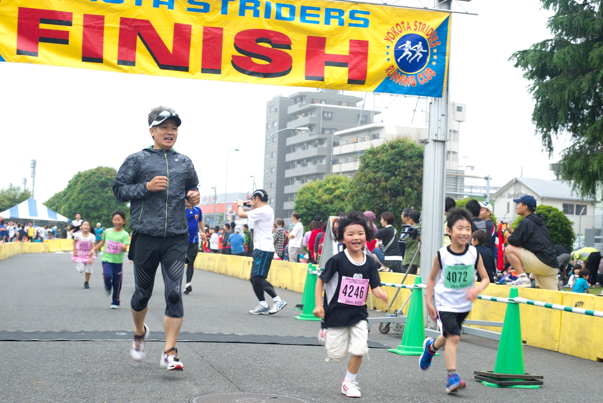 YOKOTA AIR BASE, Japan -- Runners cross the finish line after the 5K run June 3, 2012, during the 28th annual Ekiden Run at Yokota, Air Base, Japan. The event was open to the public and all categories of runners including children, beginners and experienced runners. (U.S. Air Force photo by Staff Sgt. Stacy Moless)