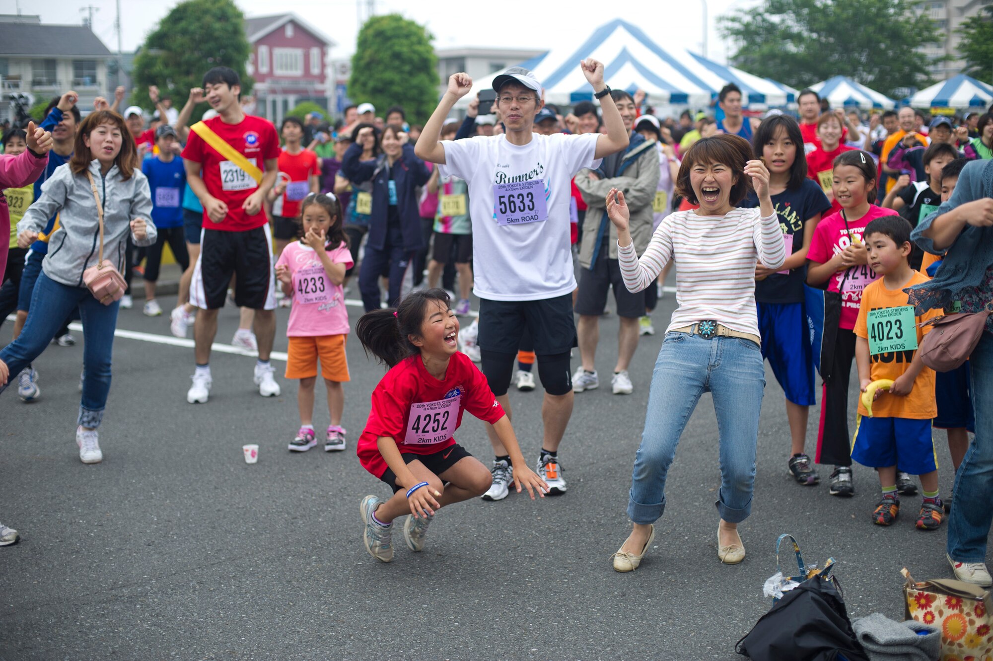 YOKOTA AIR BASE, Japan -- Japanese community members participate in a Zumba warm up June 3, 2012, during the 28th annual Ekiden Run at Yokota, Air Base, Japan. Zumba is a workout consisting mostly of Latin-dance-based moves. Sessions were conducted between the races to help stretch and warm up the runners' muscles. (U.S. Air Force photo by Staff Sgt. Stacy Moless)