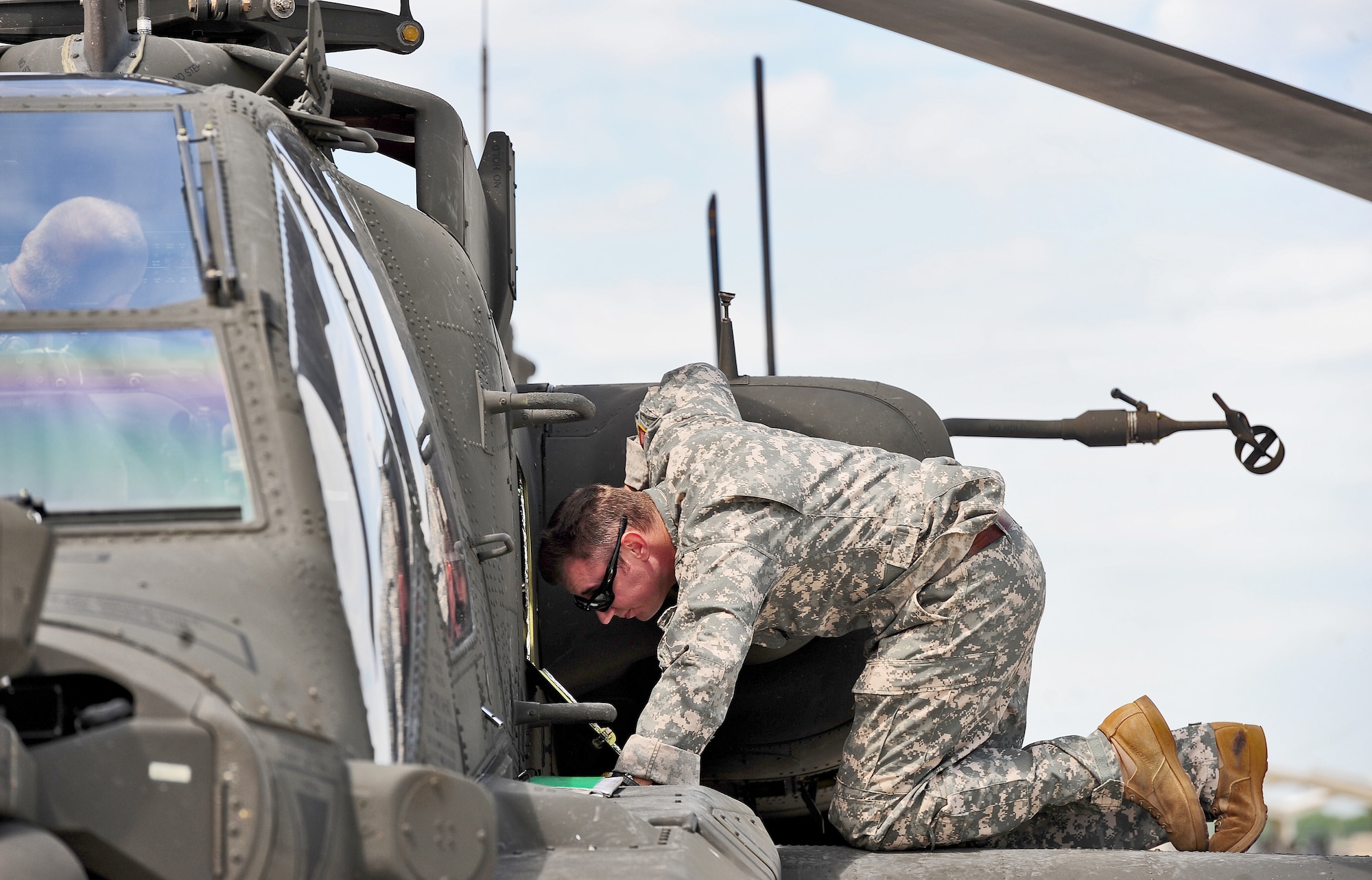 WHITEMAN AIR FORCE BASE, Mo. -- U.S. Army Chief Warrant Officer Allen Crist, 1-135th Attack Reconnaissance Battalion AH-64D Apache Longbow pilot, performs a pre-flight check on an AH-64D Apache Longbow April 24, 2012. The Longbow remanufacture effort incorporates upgraded radar and weapons capabilities, and improved cockpit management. (U.S. Air Force photo/Senior Airman Nick Wilson) (Released)