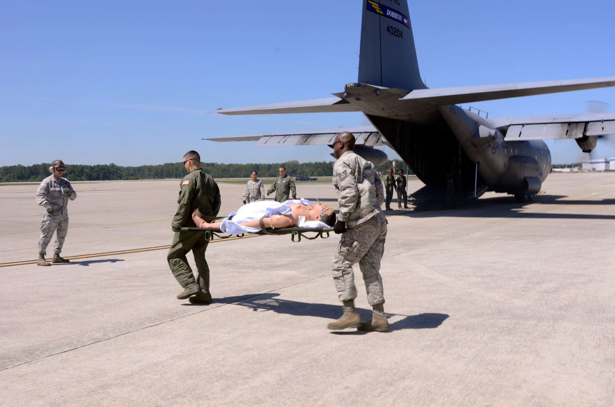Reservists from the 94th Aeromedical Evacuation Squadron carry a simulation patient during a medical evacuation scenario demonstrated for visiting employers touring Dobbins for Employer Appreciation Day May 2. (U.S. Air Force photo/Don Peek)