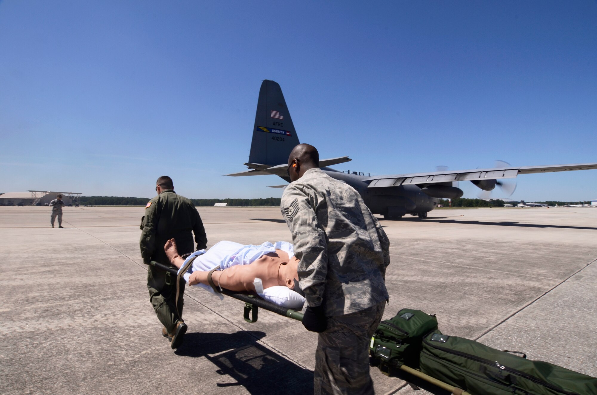 Reservists from the 94th Aeromedical Evacuation Squadron carry a simulation patient during a medical evacuation scenario demonstrated for visiting employers touring Dobbins for Employer Appreciation Day May 2. (U.S. Air Force photo/Don Peek)