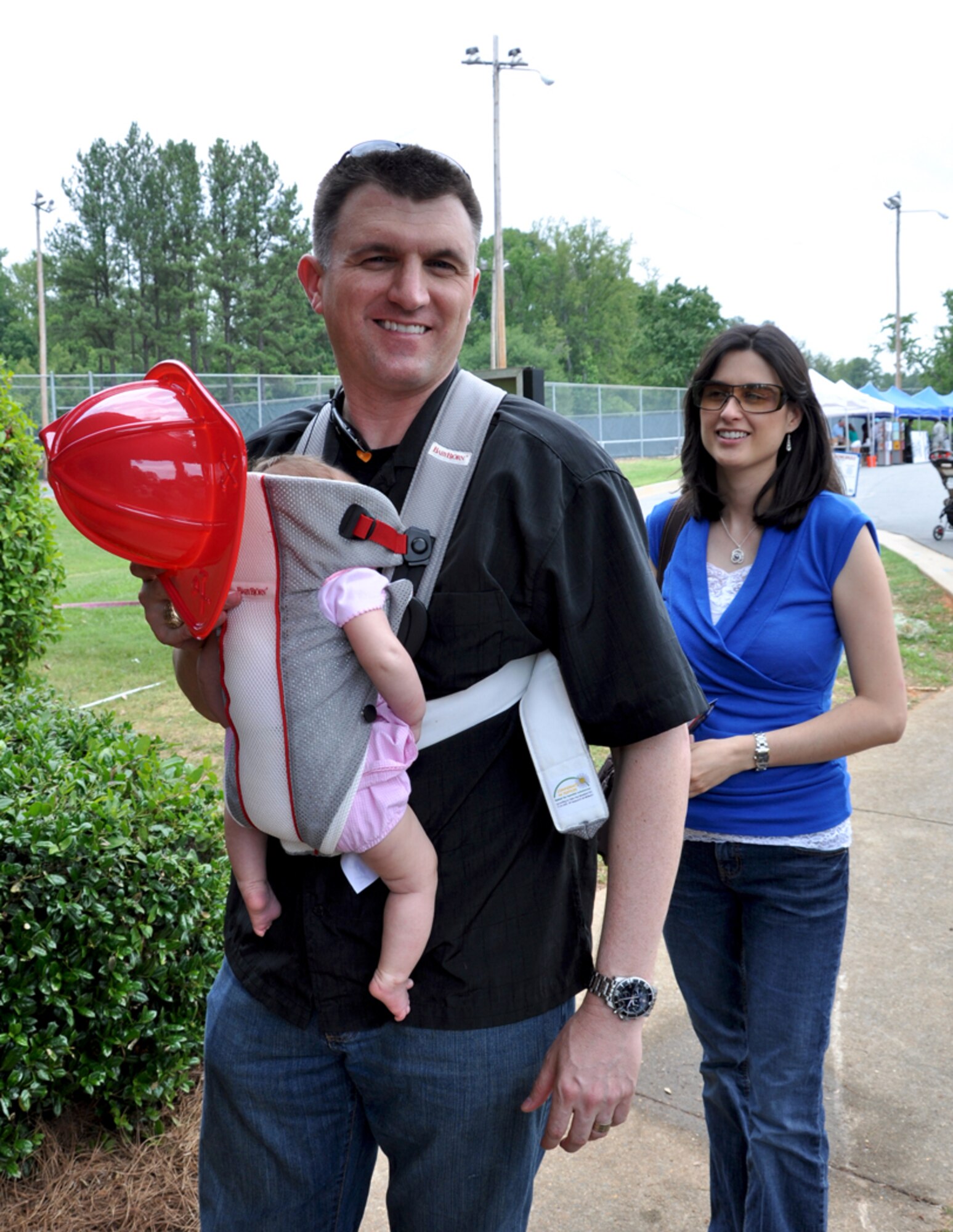 Capt. Patrick H. Simmons, 94th Airlift Wing public affairs officer, navigates through Family Day on June 3 with his wife and daughter. Family Day is an annual event celebrating the support family members give Dobbins Airmen. (U.S. Air Force photo/Senior Airman Elizabeth Gaston)