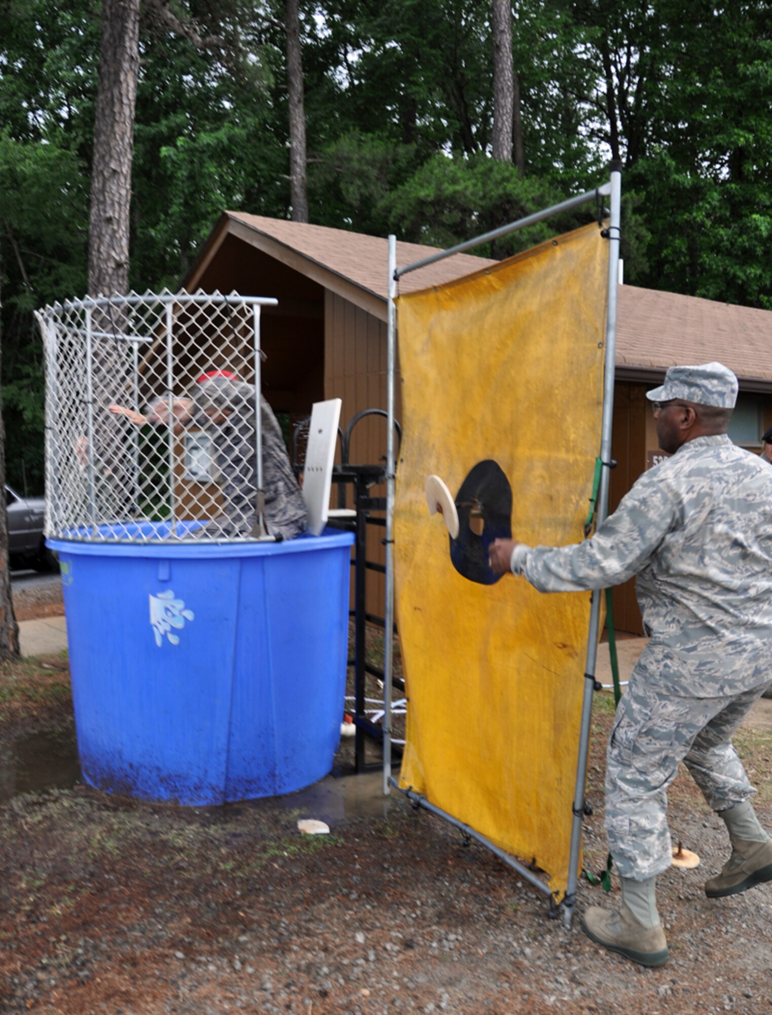 Col. Marshall S. Irving Jr., 94th Airlift Wing Mission Support Group commander, sneaks up to the tank to dunk Col. Timothy E. Tarchick, 94th Airlift Wing commander, at Family Day on June 3. (U.S. Air Force photo/Senior Airman Elizabeth Gaston)