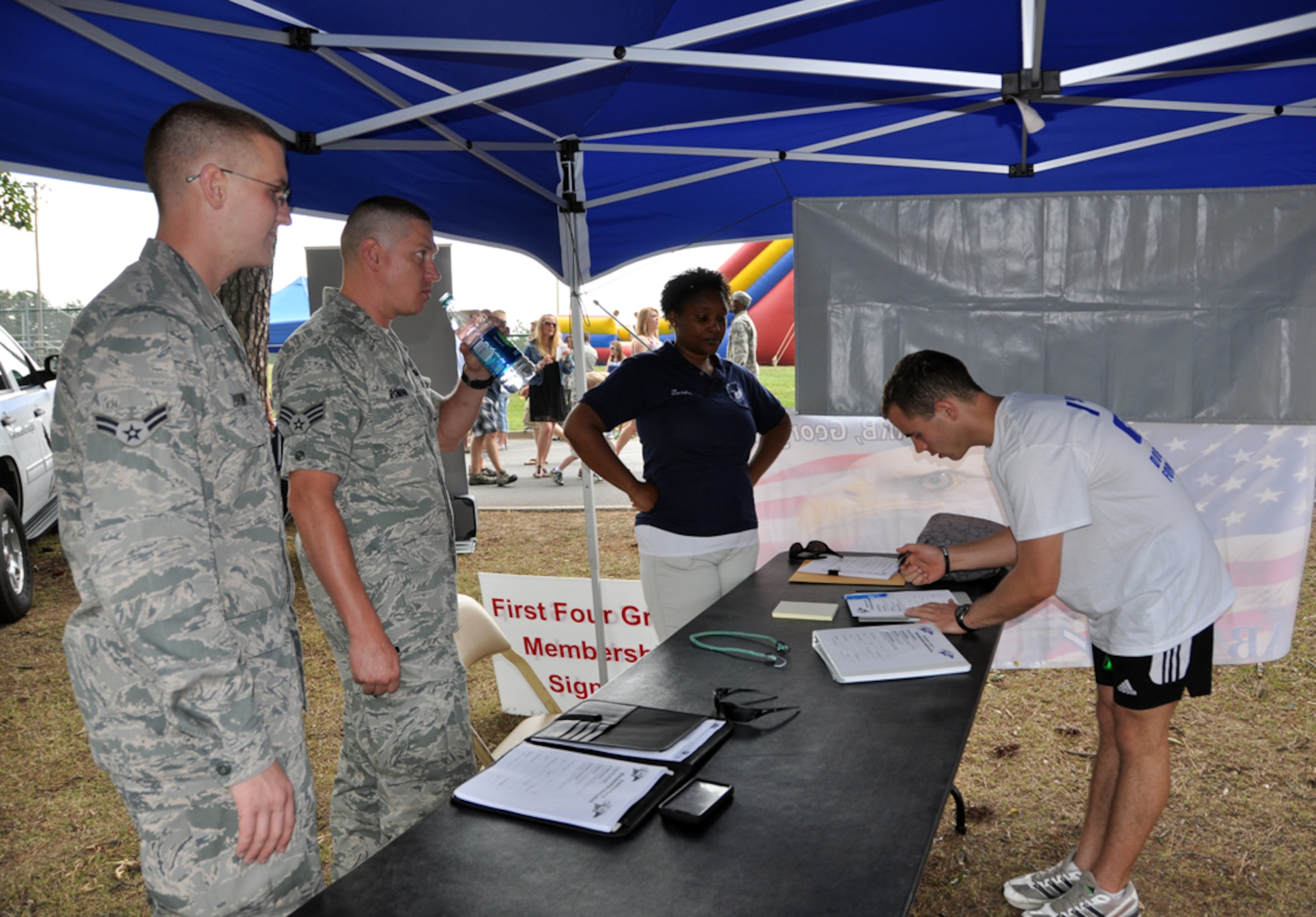Senior Airman Michael Roman, of the 94th Maintenance Group and president of the Dobbins First Four, and Airman 1st Class Dylan Brown, of the 94th Maintenance Group, sign up potential members for the First Four under the mentorship of the 56 Group. This tent, along with many other tents, housed places for Dobbins Air Reserve Base Airmen to gain information on various subjects from financial planning and education to volunteer opportunities at Family Day on June 3. (U.S. Air Force photo/Senior Airman Elizabeth Gaston)