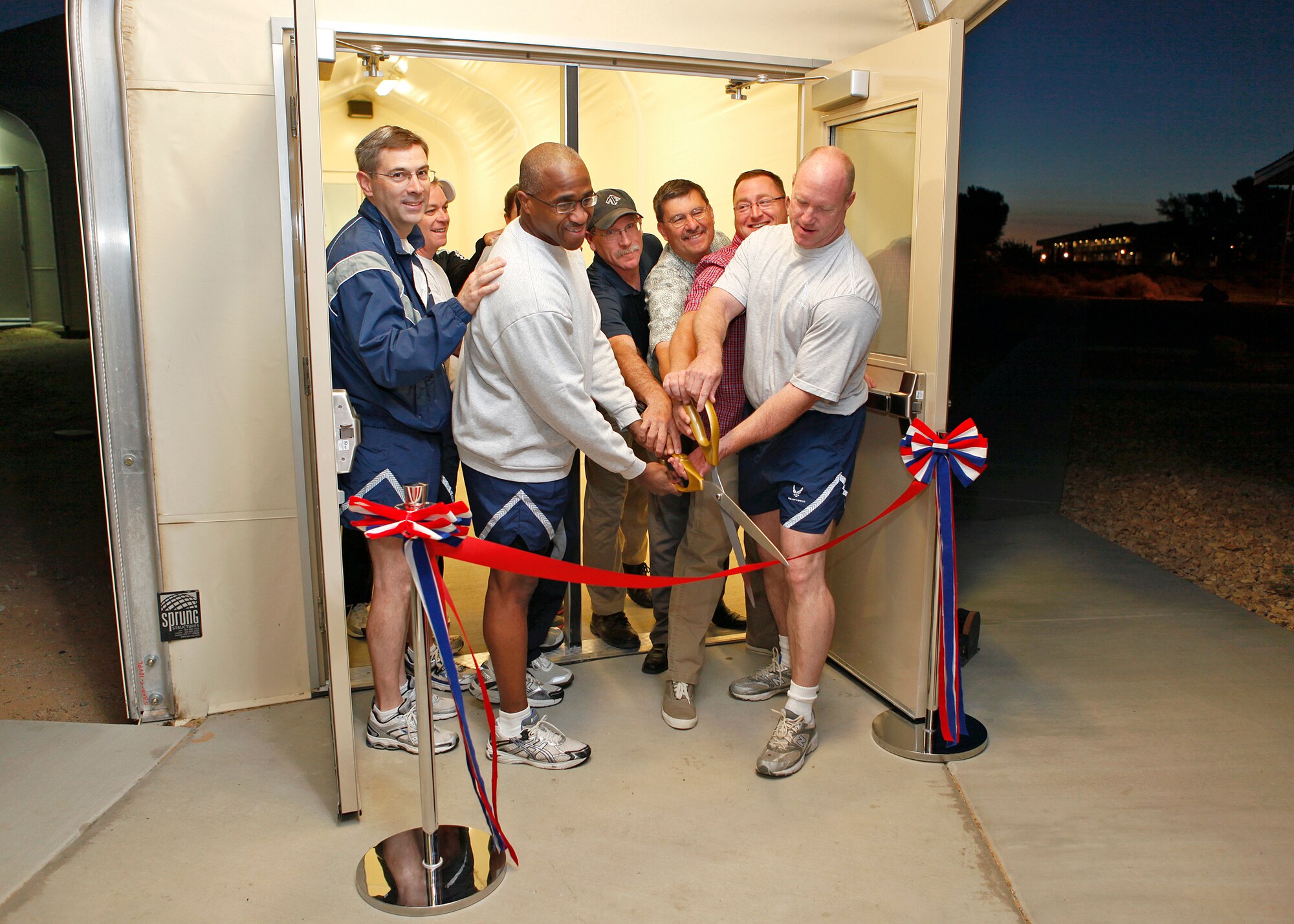 Front, from left: Col. Gregory Schwab, 95th Air Base Wing commander, Chief Master Sgt. William Green, 95th Security Forces Squadron superintendent, and Brig. Gen. Robert C. Nolan II, cut the ceremonial ribbon to offically open the new High Intensity workout facility at the base gym June 4, while surrounded by gym staff. (U.S. Air Force photo by Jet Fabara)   