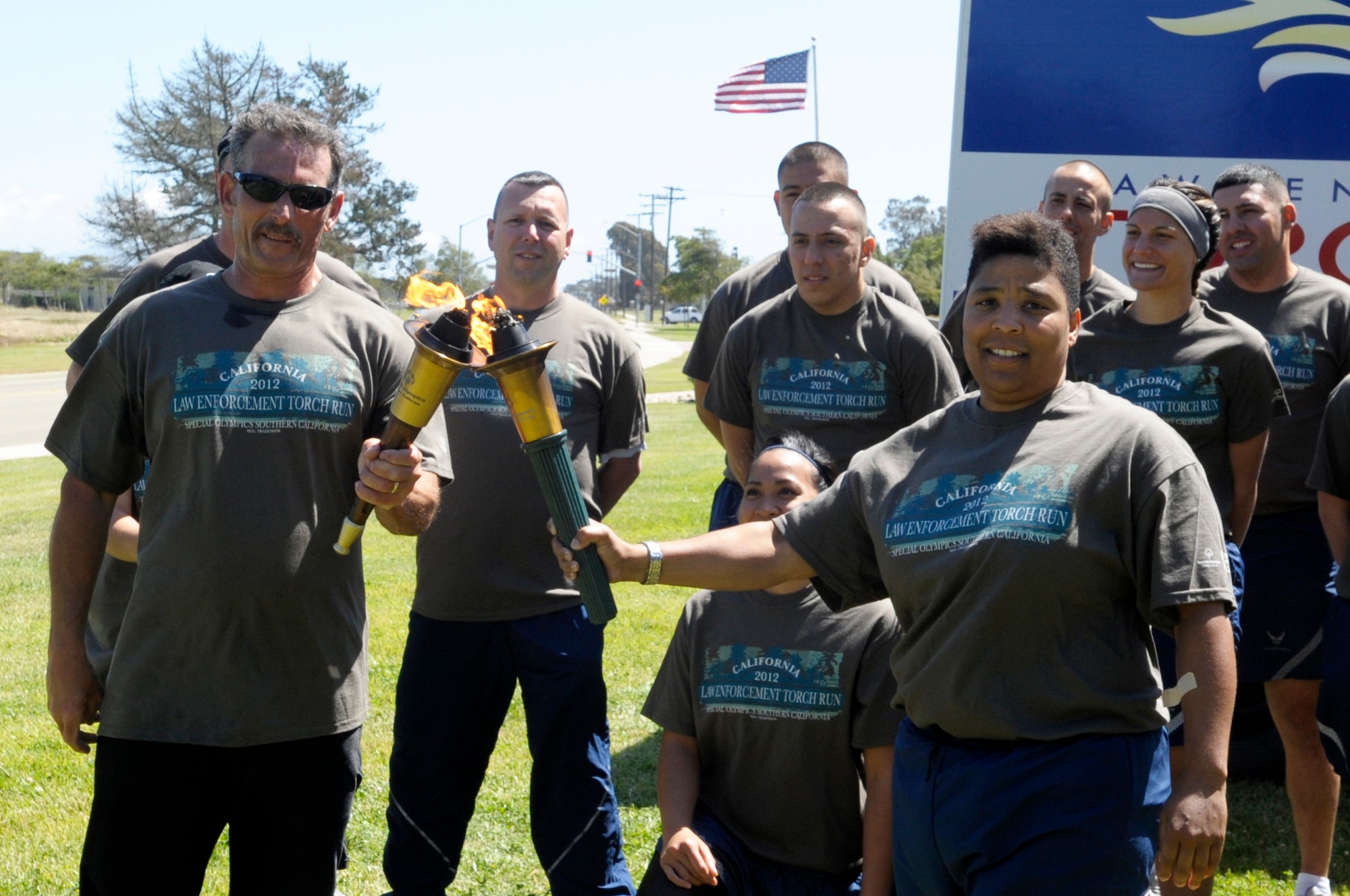 VANDENBERG AIR FORCE BASE, Calif. -- Santa Barbara County Sheriff deputies run the Special Olympics torch down California Boulevard, passing it to 30th Security Forces Squadron members here, Tuesday, June 5, 2012. The Law Enforcement Torch Run passes through Santa Barbara County before its arrival at California State University, Long Beach for the Special Olympics Southern California Summer Games. (U.S. Air Force photo/Jerry E. Clemens Jr.)