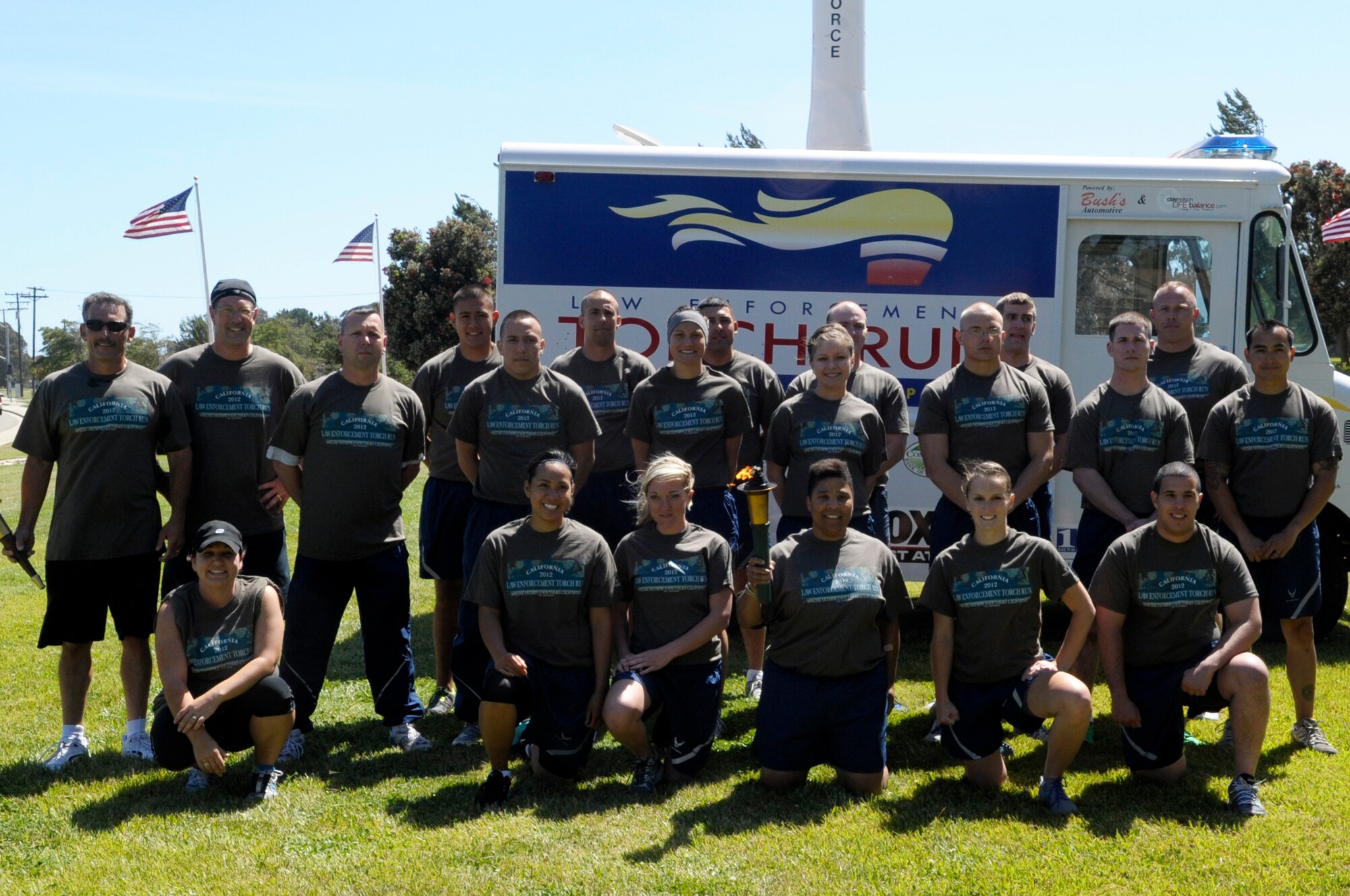 VANDENBERG AIR FORCE BASE, Calif. -- Santa Barbara County Sheriff deputies run the Special Olympics torch down California Boulevard, passing it to 30th Security Forces Squadron members here, Tuesday, June 5, 2012. The Law Enforcement Torch Run passes through Santa Barbara County before its arrival at California State University, Long Beach for the Special Olympics Southern California Summer Games. (U.S. Air Force photo/Jerry E. Clemens Jr.)