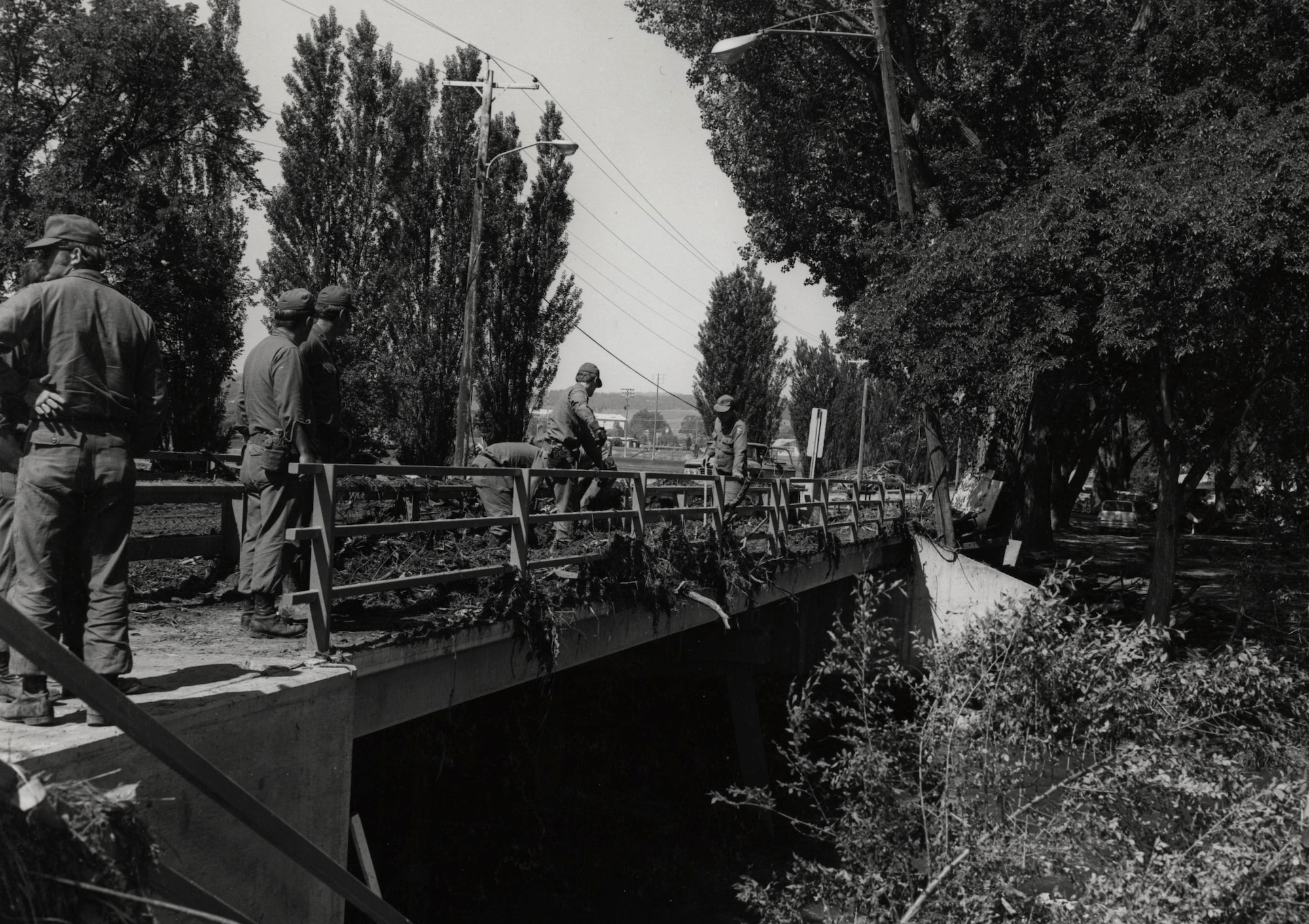 Ellsworth Airmen clear fallen trees from a bridge after the flood in Rapid City, S.D., June 11, 1972. In addition to providing equipment, supplies and support, Ellsworth’s Family Services staff set up a relief station in the Base Community Center, offering free clothing, food and shelter to disaster victims. (U.S. Air Force courtesy photo)