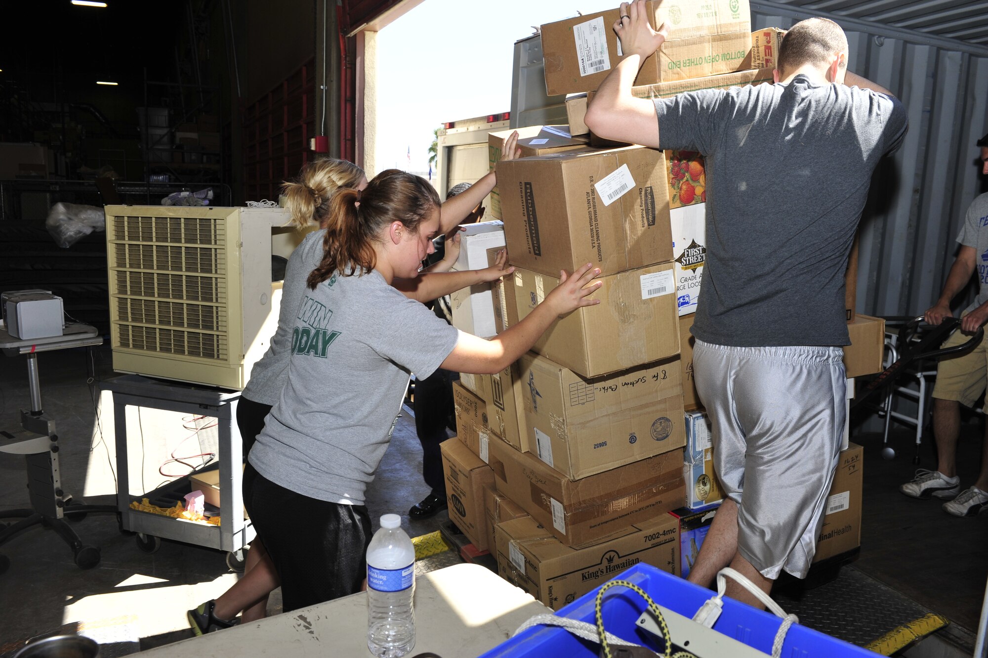 Members of the 56th Security Forces Squadron push a pallet of boxes into a shipping container at the Project Commission on Urgent Relief & Equipment warehouse in Mesa, Ariz., May 31, 2012. The medical supplies, valued at approximately $500,000, were designated for a shipment bound for Guatemala. (U.S. Air Force photo by Staff Sgt. Jason Colbert)