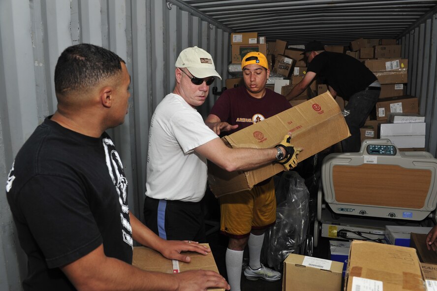 Members of the 56th Security Forces Squadron load boxes into a shipping container at the Project  Commission on Urgent Relief & Equipment warehouse in Mesa, Ariz., May 31, 2012. Project C.U.R.E. ships an average of $500,000 of medical equipment every two weeks to developing countries around the world. (U.S. Air Force photo by Staff Sgt. Jason Colbert)
