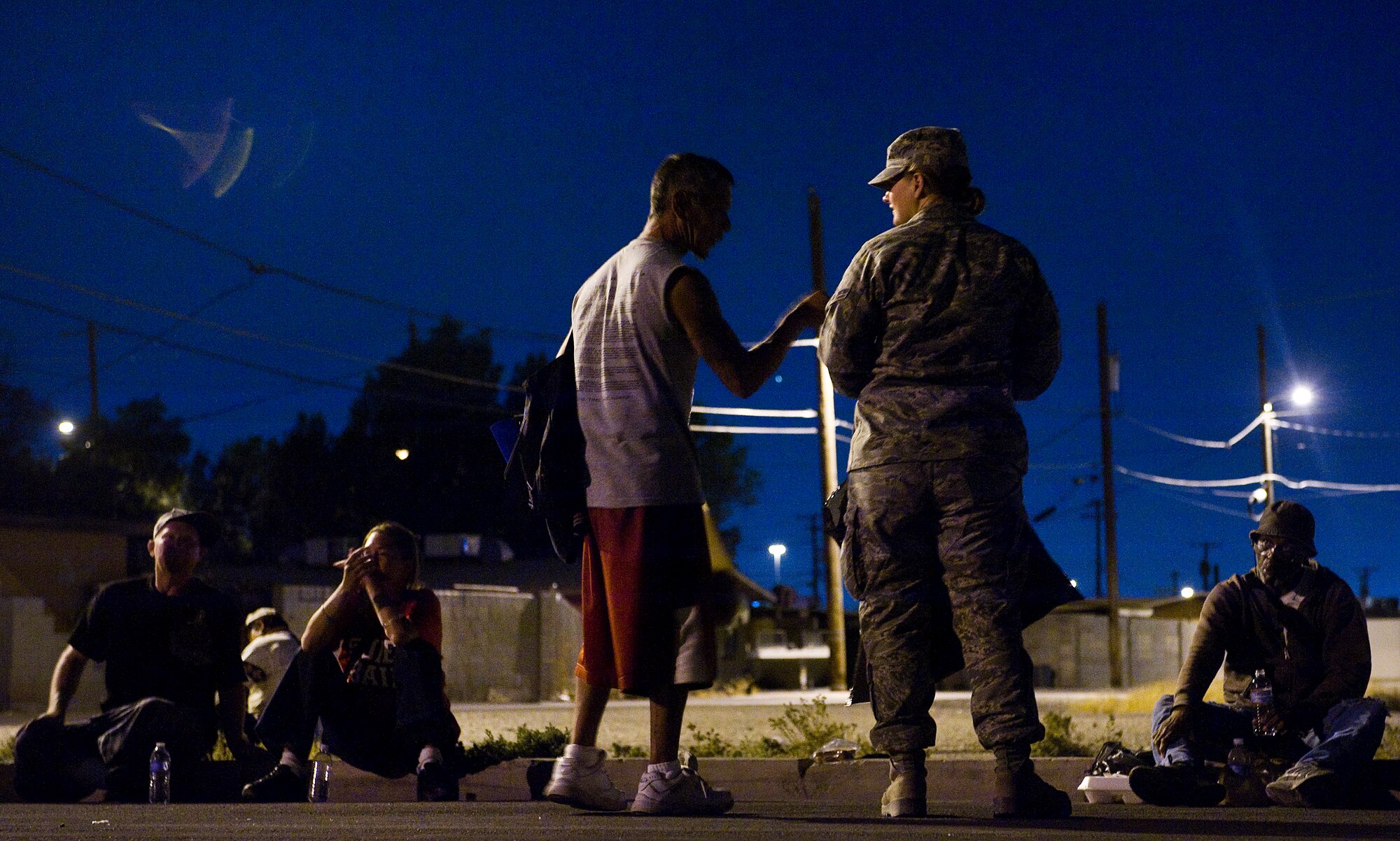 A 99th Logistics Readiness Squadron Airman and a man living in the local area share conversation during a monthly Top-3 Food Drive for the Homeless event Apr. 30, 2012, in Las Vegas. Volunteers from the base took time out to feed homeless and disadvantaged members of the community. (U.S. Air Force photo by Staff Sgt. Christopher Hubenthal)