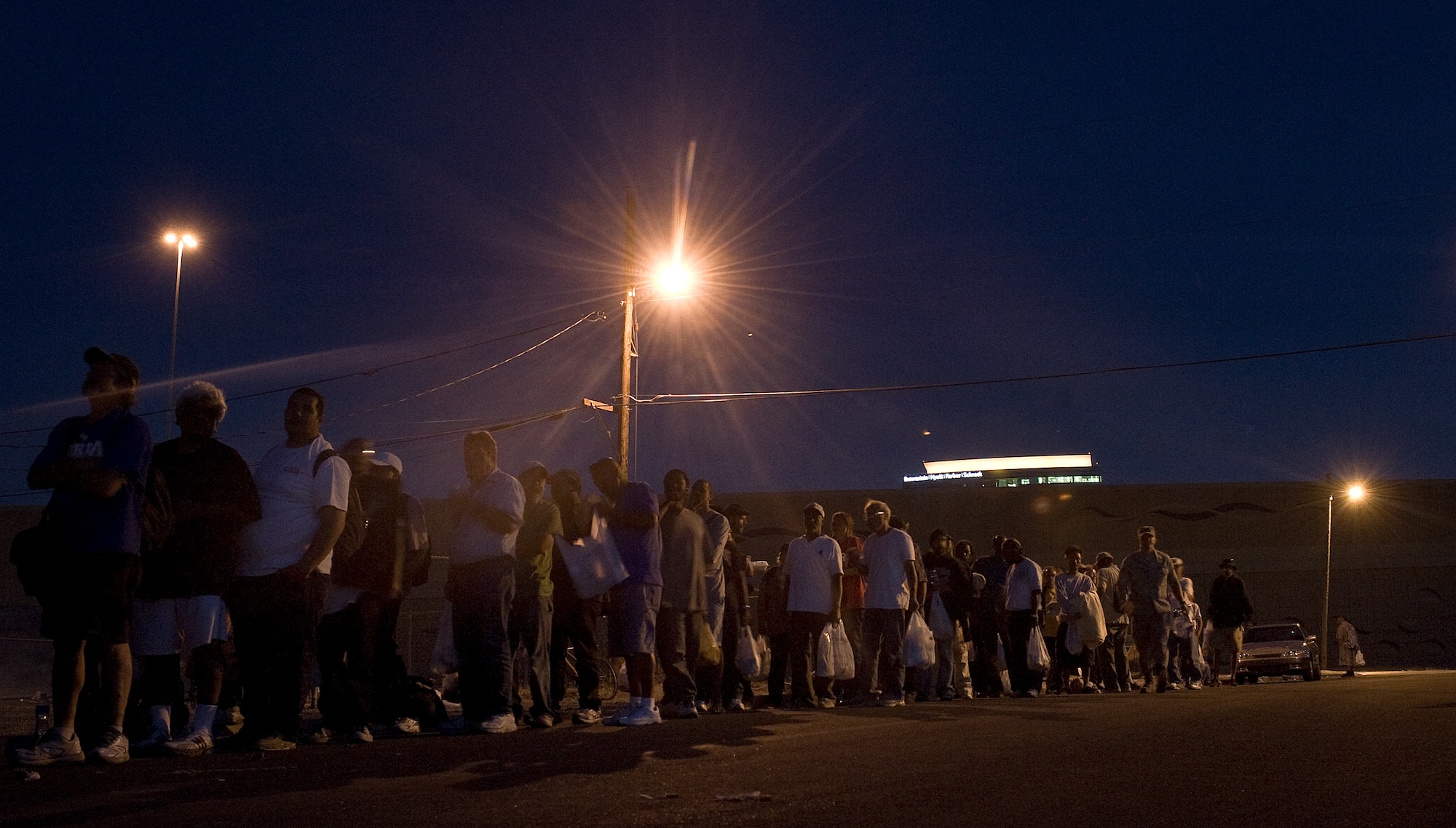 The line grows as 99th Logistics Readiness Squadron Airmen from Nellis Air Force Base, Nev. serve food to the local community during a monthly Top-3 Food Drive for the Homeless event Apr. 30, 2012, in Las Vegas. 99 LRS fed 250 people during the evening's event. (U.S. Air Force photo by Staff Sgt. Christopher Hubenthal)