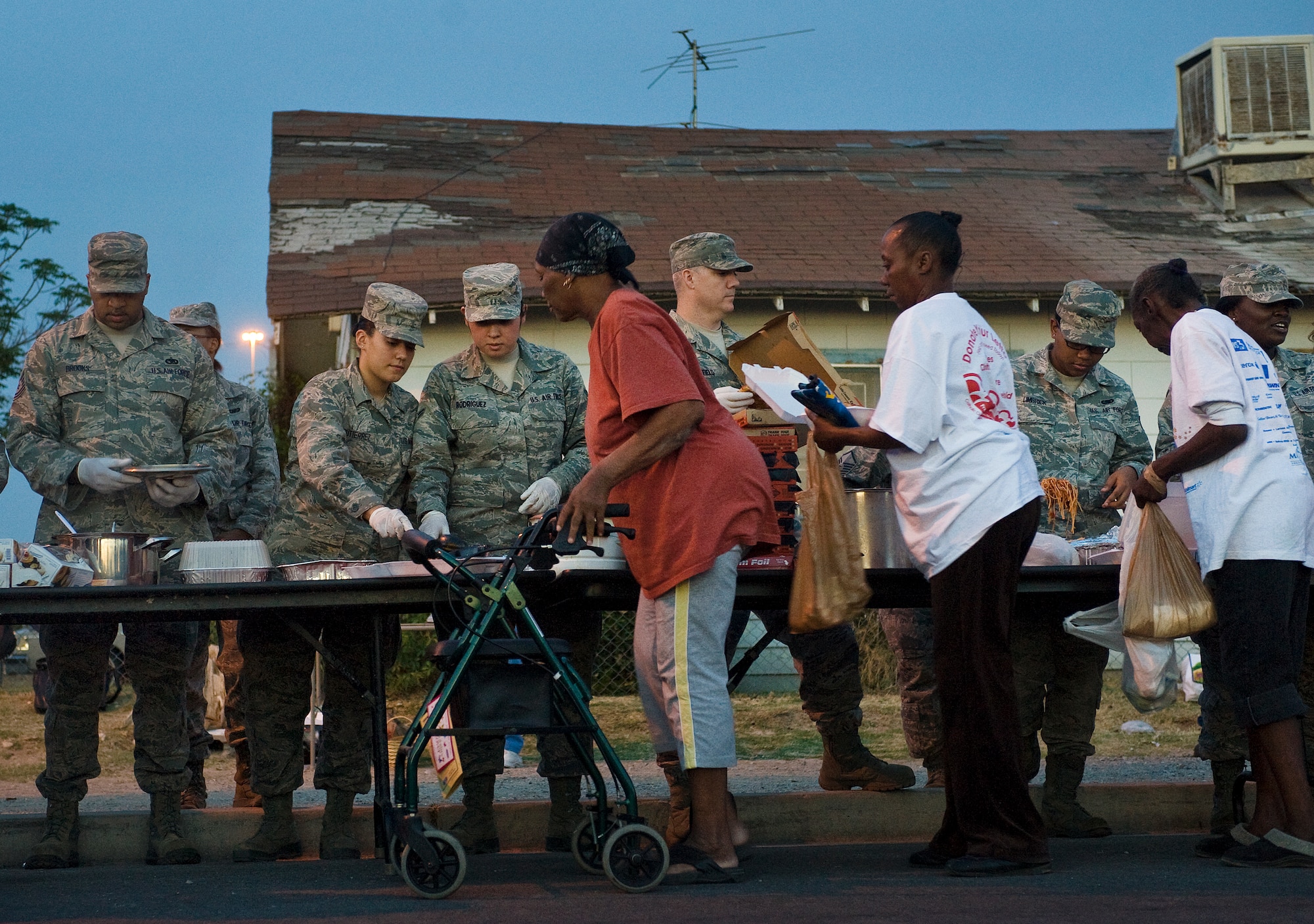 Airmen from the 99th Logistics Readiness Squadron, Nellis Air Force Base, Nev., serve food to the local community during a monthly Top-3 Food Drive for the Homeless event Apr. 30, 2012, in Las Vegas. The Airmen provided locals with pasta, pizza, rolls, and water. The Top-3 conducts the Food Drive for the Homeless event on the last Monday of every month. (U.S. Air Force photo by Staff Sgt. Christopher Hubenthal)