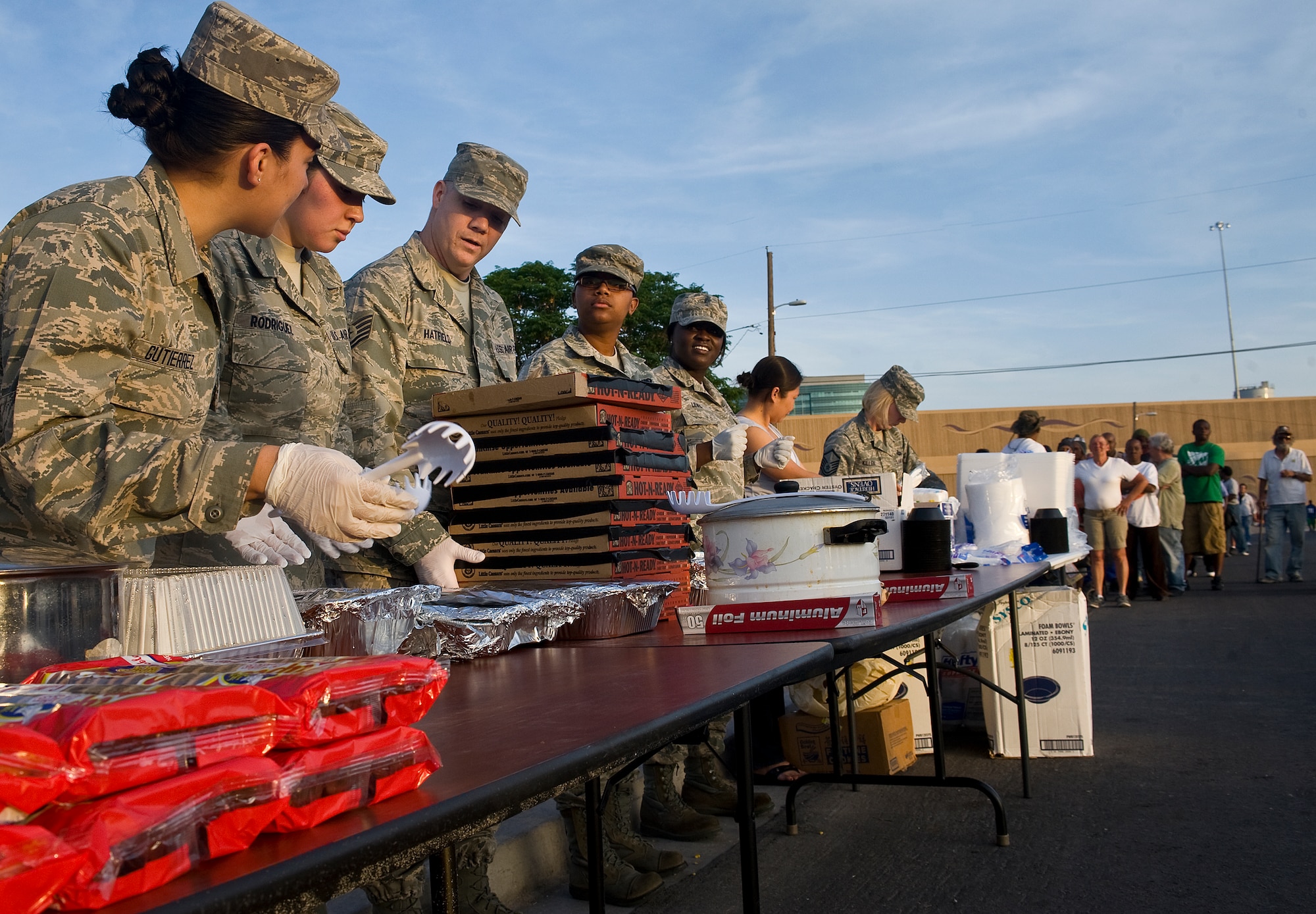 Airmen from the 99th Logistics Readiness Squadron, Nellis Air Force Base, Nev., prepare food as the monthly Top-3 Food Drive for the Homeless event begins Apr. 30, 2012, in Las Vegas. 99th LRS Airmen provided locals with pasta, pizza, rolls, and water. (U.S. Air Force photo by Staff Sgt. Christopher Hubenthal)