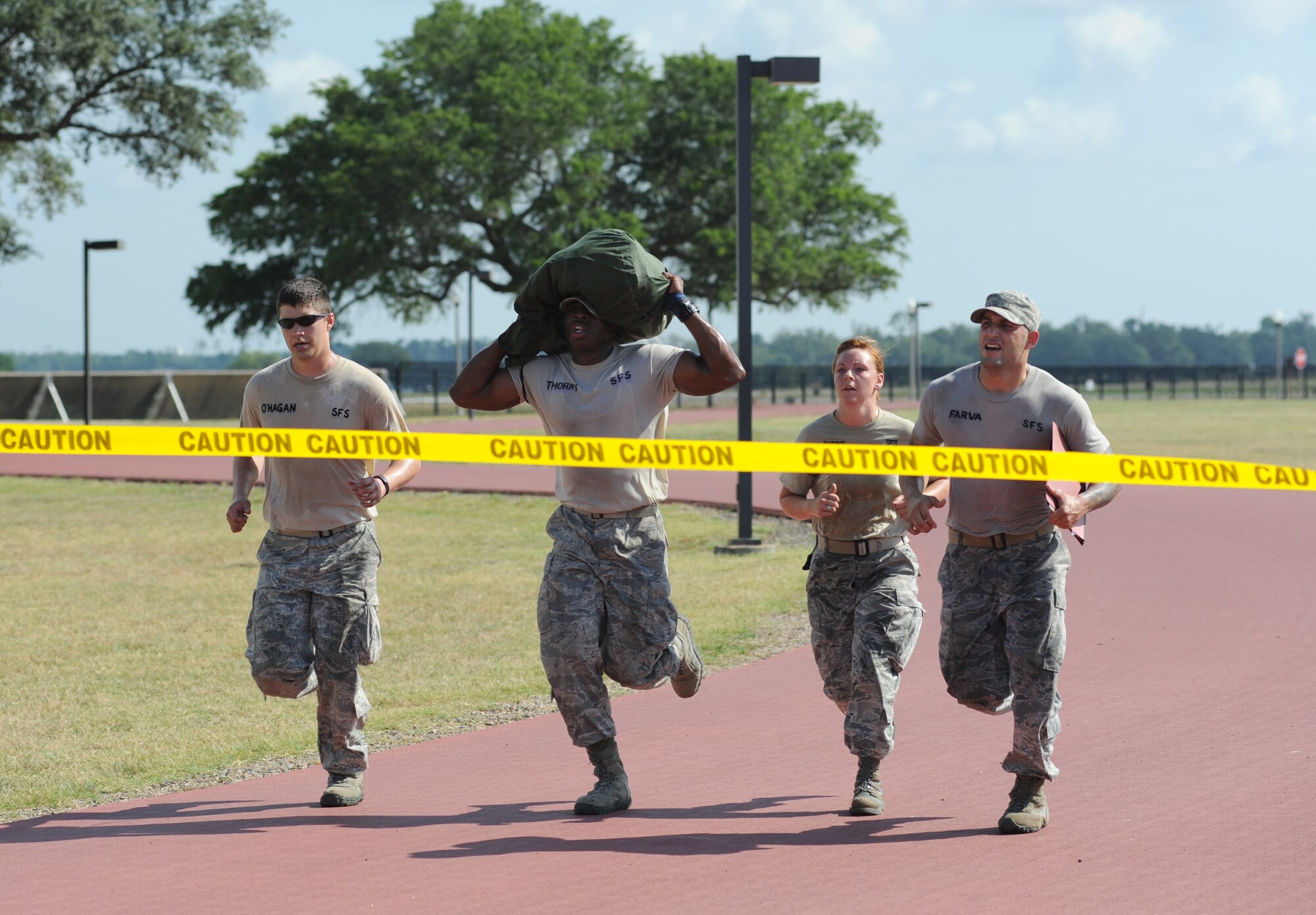 Capt. Chris Porta, Senior Airman Justin Gachett, and Staff Sgts. Audrey Spoor and Christopher Hernandez, Ram Rod team members from the 81st Security Forces Squadron, complete the “Mogadishu Mile” challenge by crossing the finish line with Gachett carrying a MOPP gear bag during the 81st Mission Support Group Ultimate Warrior Challenge June 1, 2012, at the Triangle Track at Keesler Air Force Base, Miss.  The Ram Rods took 1st place in the challenge which was held in honor of fellow service members who lost their lives in the fight for our nation’s freedom. It consisted of nine four-member teams racing in a competition designed to take them through various aspects of a deployment.  (U.S. Air Force photo by Kemberly Groue)