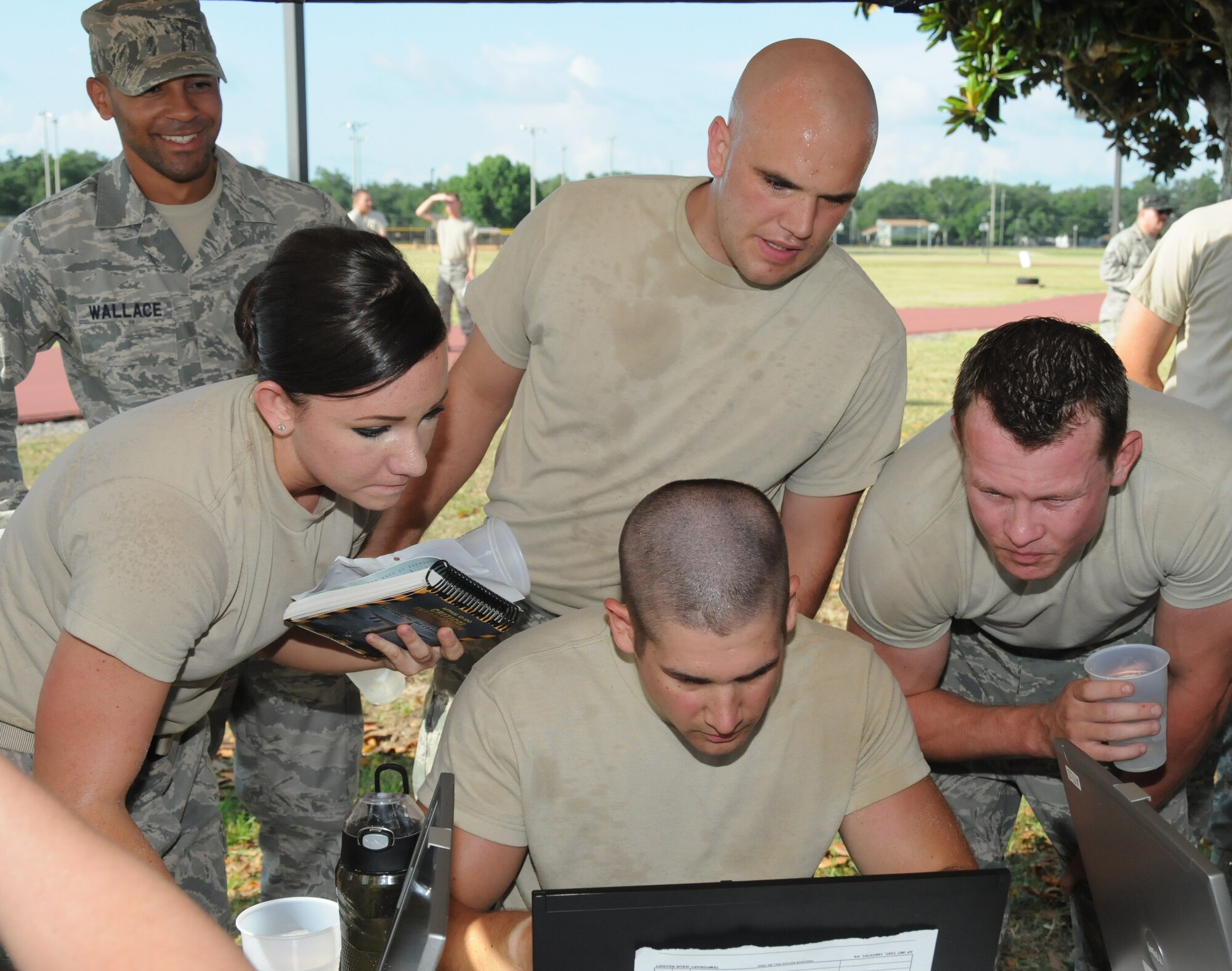 Staff Sgt. Errol Wallace, 81st Logistics Readiness Squadron, cheers on his squadron team members, Senior Airmen Patsy Chandler and Aaron Ruschau; 1st Lt. Josh Anson (sitting) and Staff Sgt. Blaine Hunter, as they complete the challenge, “are you smarter than a first termer?” during the 81st Mission Support Group Ultimate Warrior Challenge June 1, 2012, at the Triangle Track at Keesler Air Force Base, Miss.  The Log Monsters have to complete a 25 question quiz as quickly as possible on a computer before moving on to the next challenge.  The challenge was held in honor of fellow service members who lost their lives in the fight for our nation’s freedom. It consisted of nine four-member teams racing in a competition designed to take them through various aspects of a deployment.  (U.S. Air Force photo by Kemberly Groue)