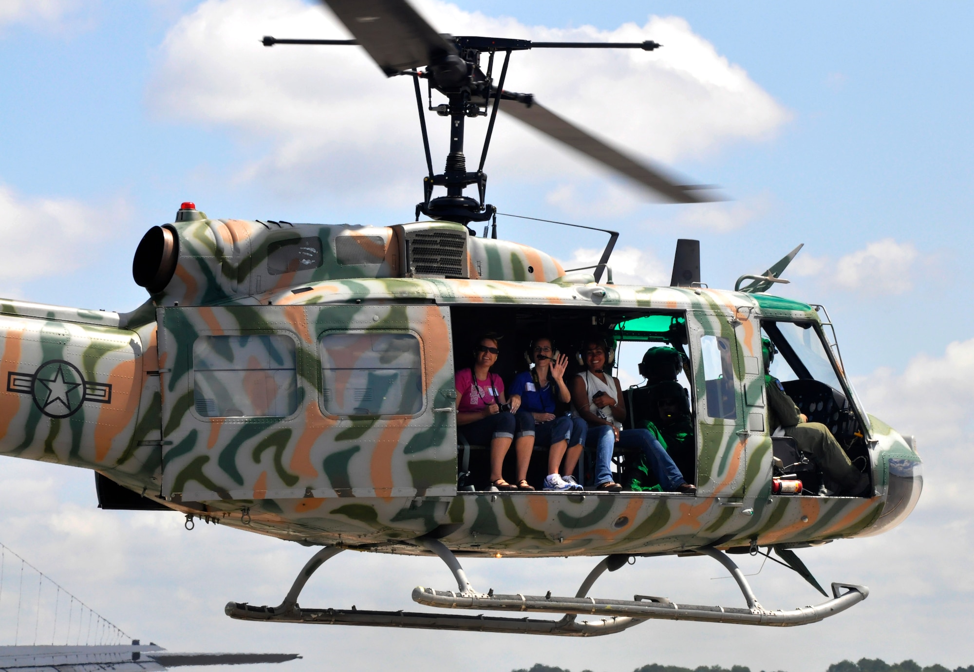 A group of 1st Special Operations Wing spouses wave from a UH-1 from the 6th Special Operations Squadron during Commando Spouse Day at the flightline at Hurlburt Field, Fla., May 19, 2012. Many spouses had an opportunity to fly on the helicopter as well as other 1st SOW aircraft at the event. (U.S. Air Force photo / Senior Airman Joe McFadden) (Released)